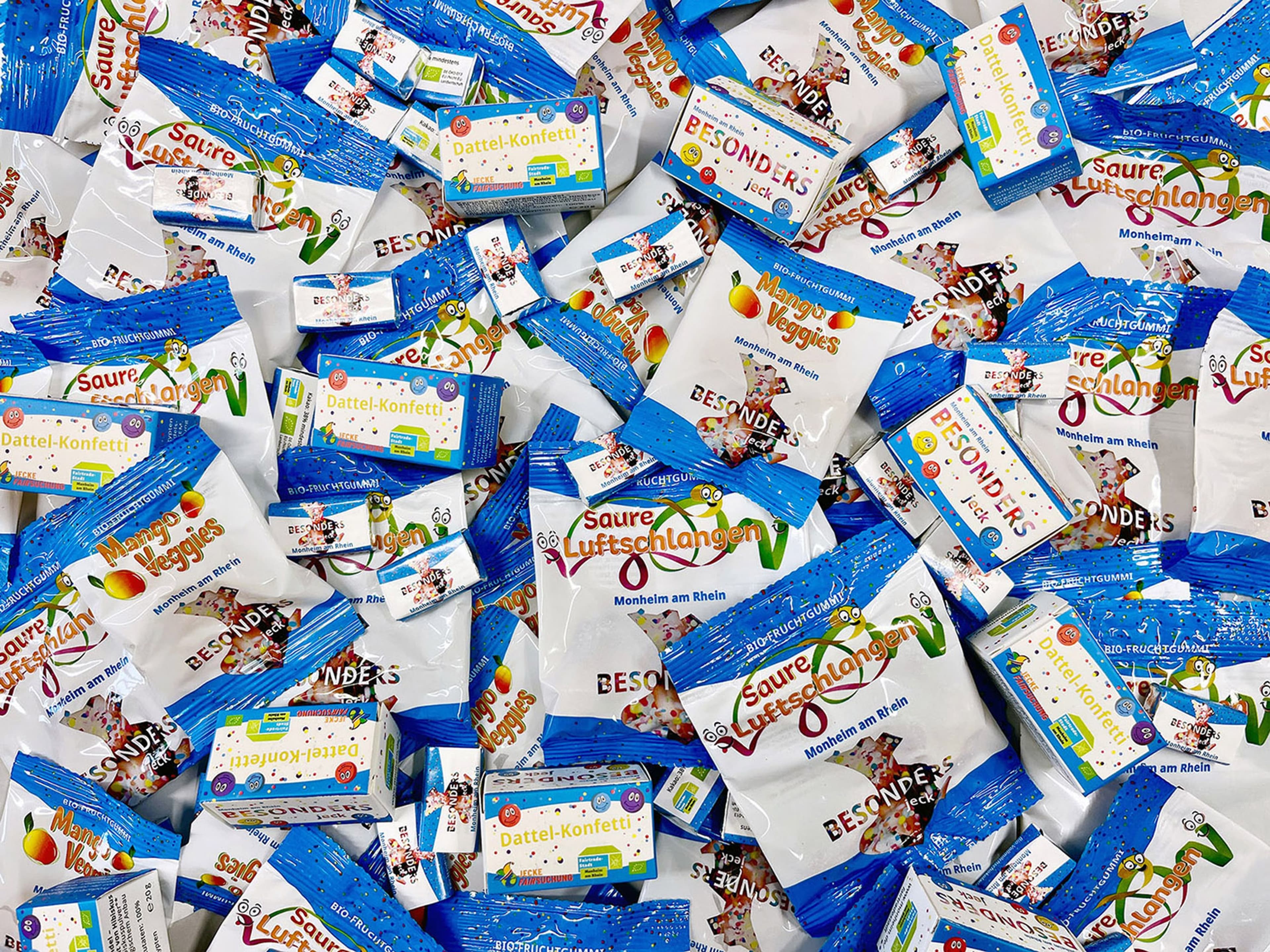 Engagierte Beschäftigte des Betriebshofs packen Kamelle-Pakete für die Karnevalszüge., Kleine und große Jecken freuen sich über Saure Luftschlangen, Mango Veggies, Schokolade und Dattel-Konfetti. Engagierte Beschäftigte des Betriebshofs packen Kamelle-Pakete für die Karnevalszüge., Kleine und große Jecken freuen sich über Saure Luftschlangen, Mango Veggies, Schokolade und Dattel-Konfetti.