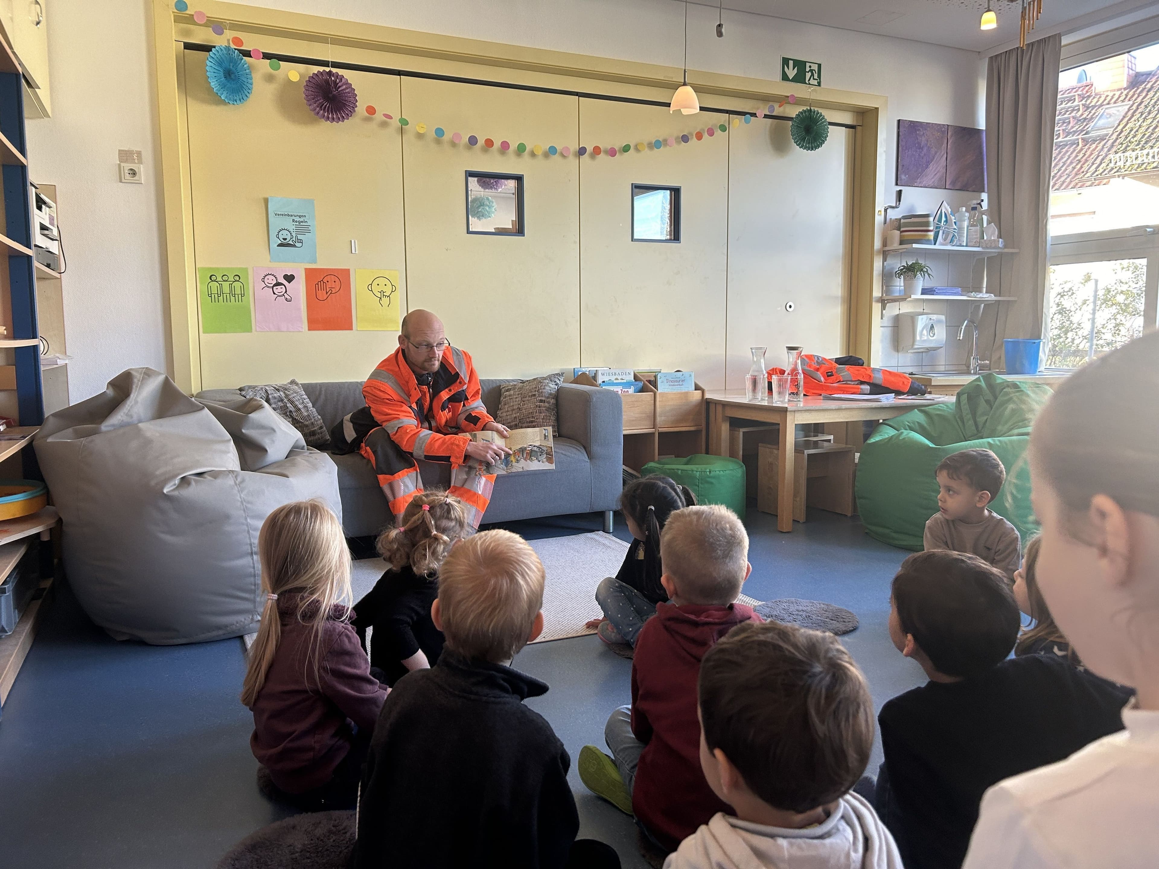 Kehrmaschinenfahrer liest im Kindergarten vor | Symbolbild