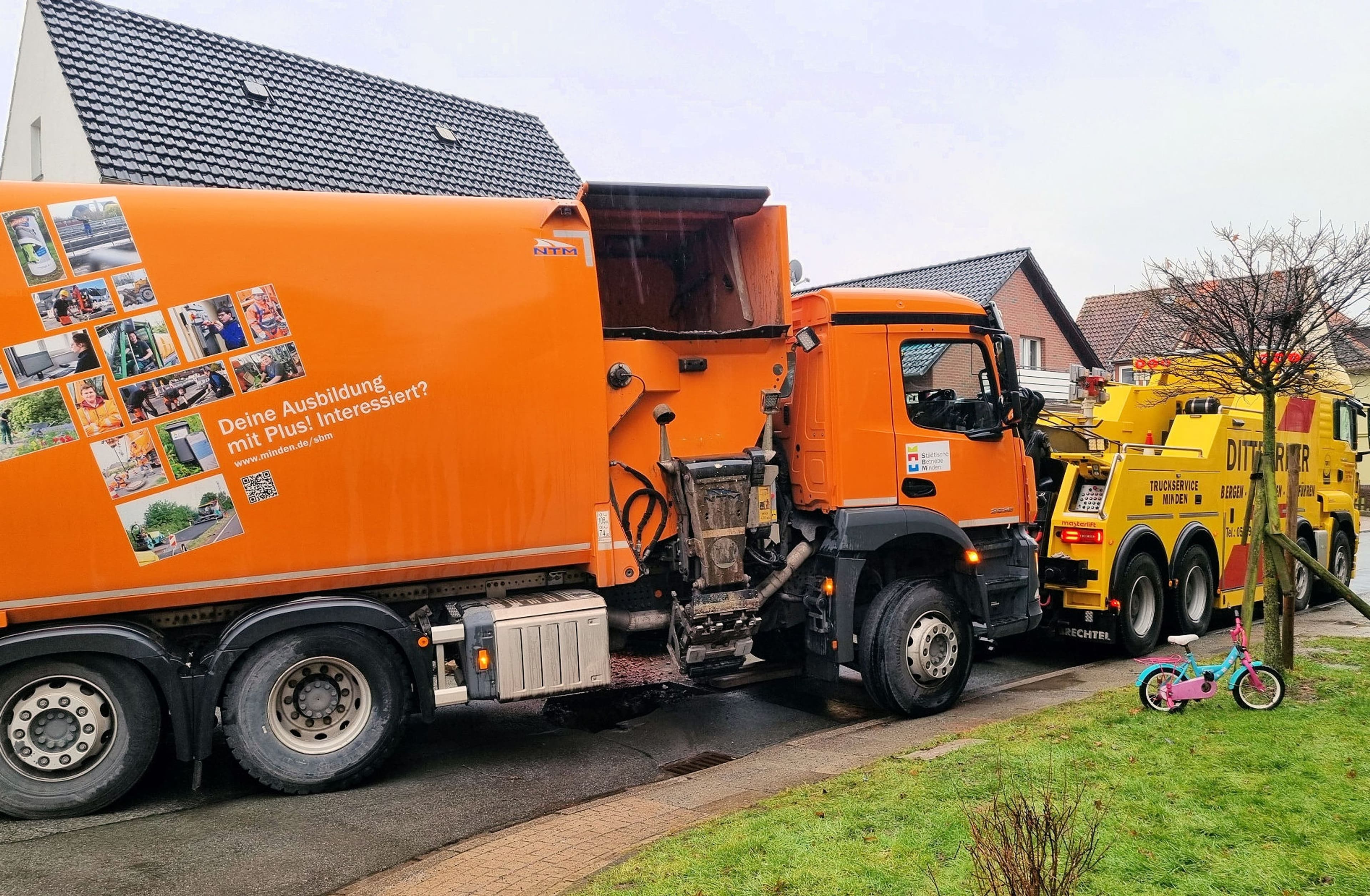 Müllsammelfahrzeug steckt auf abgesenkter Straße in Minden fest und wird geborgen.