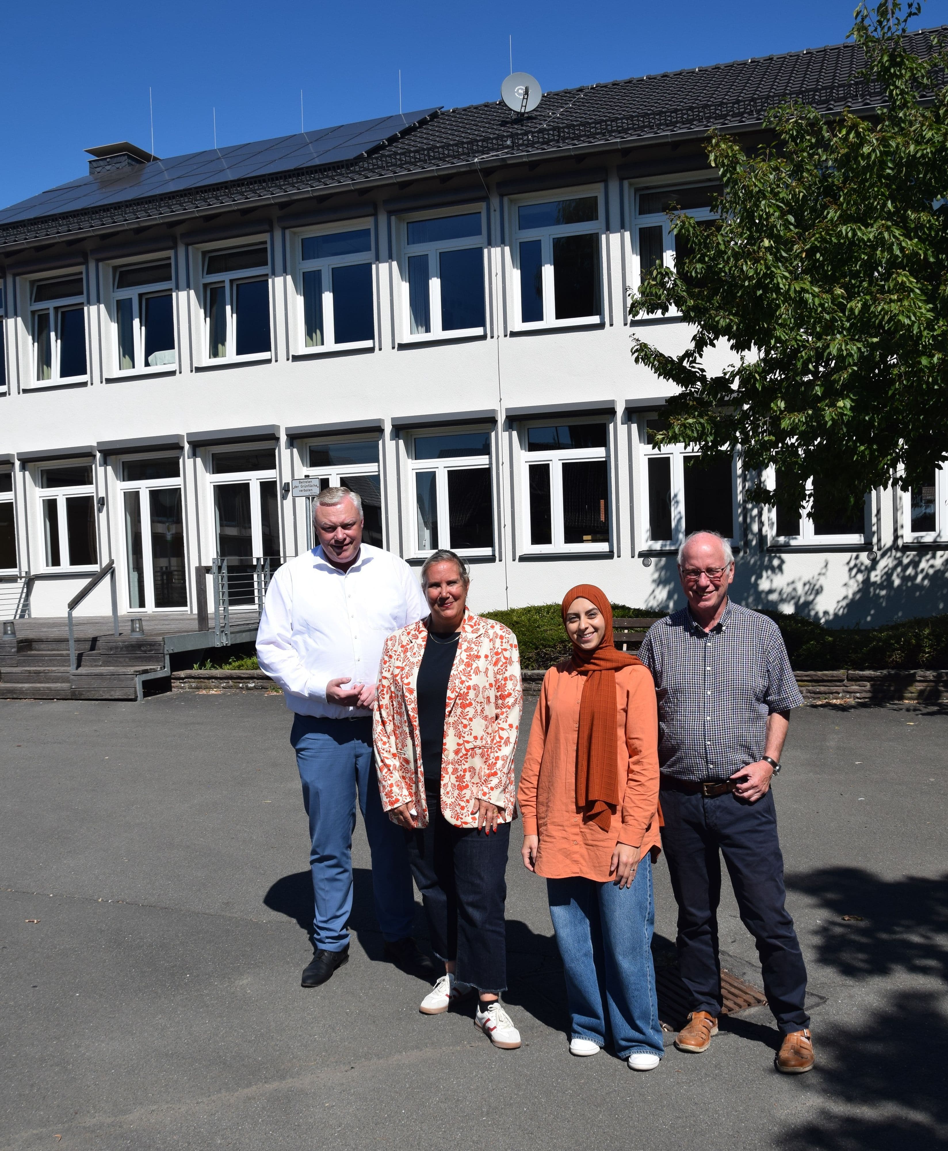 Daniel Hartmann, Julia Gogrewe, Emine Yesilgöz und Hans-Josef Held vor dem Dorfgemeinschaftshaus Godelheim.