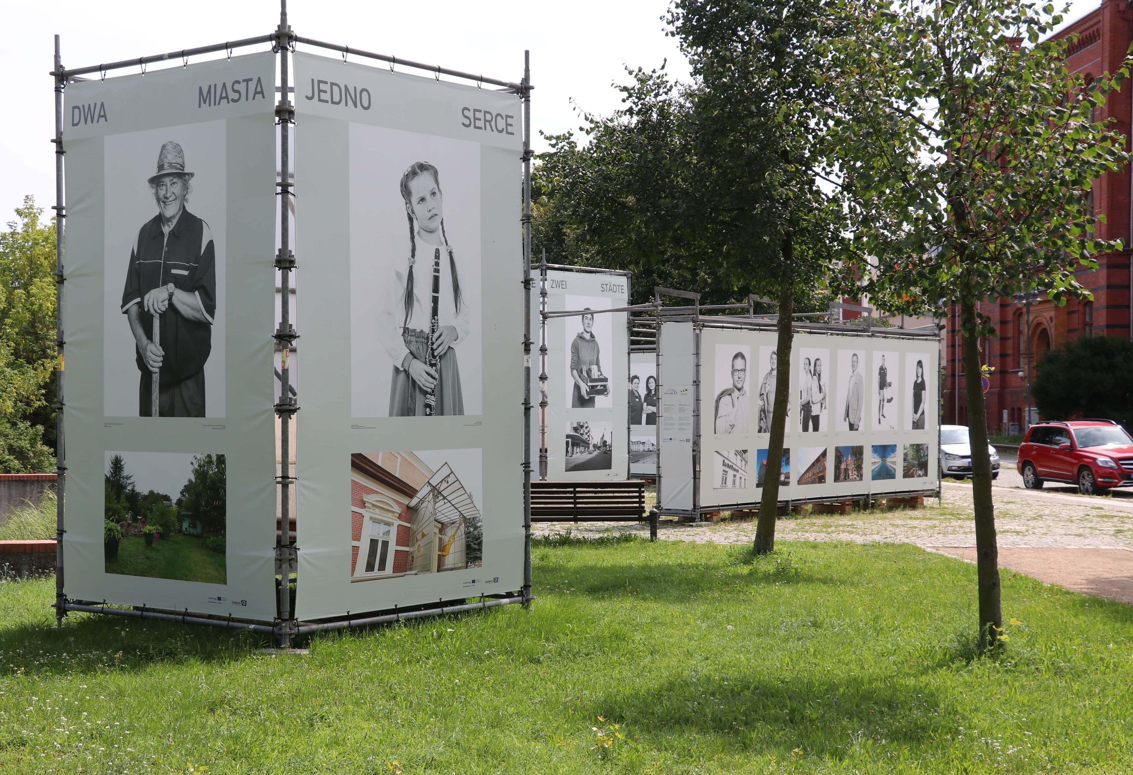 Großformatige Fotoausstellung mit Porträts und Stadtansichten beiderseits der Neiße.