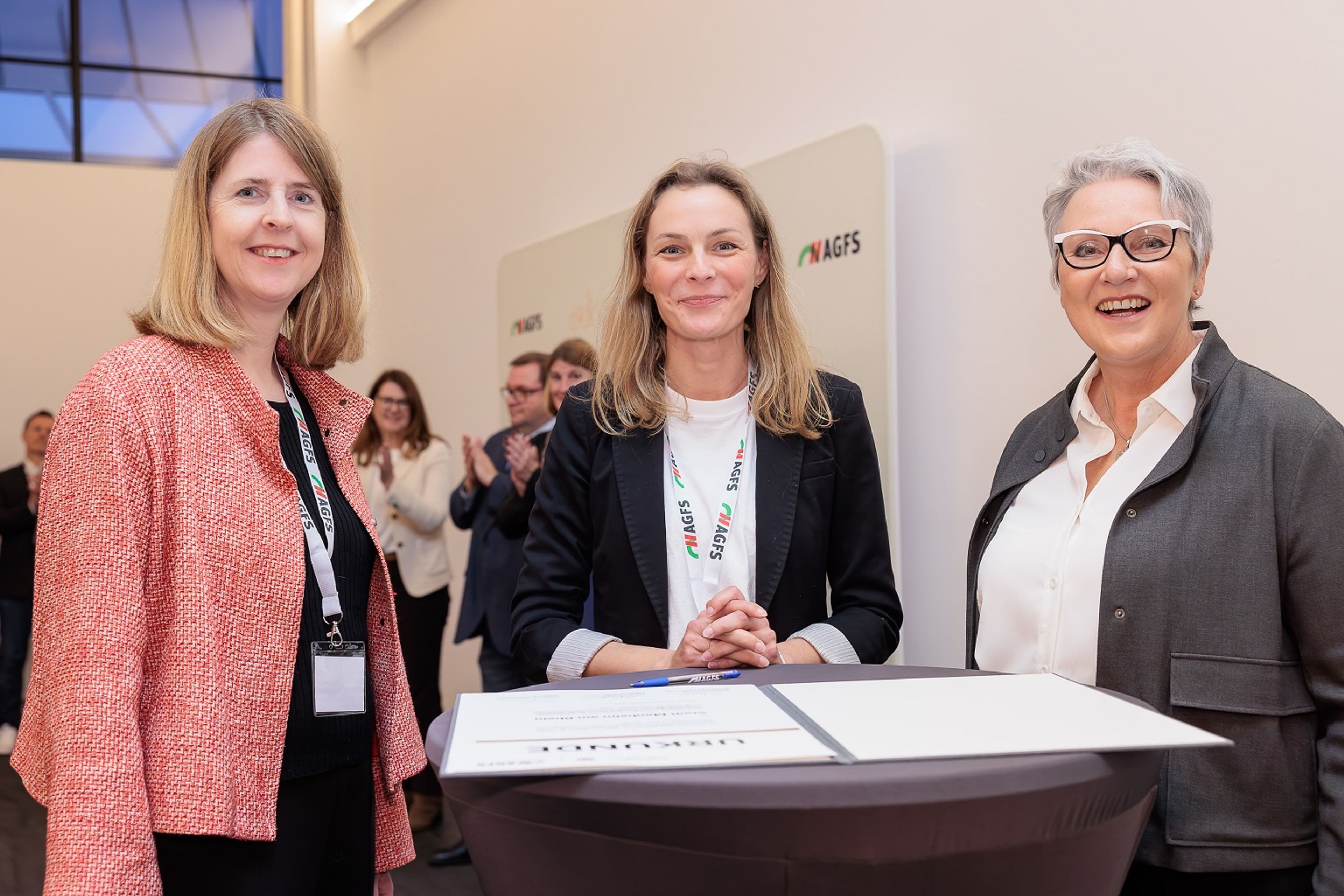 Führungskräfte unterzeichnen AGFS-Mitgliedschafts-Urkunde bei feierlicher Verlängerung., Stadt- und Landesvertreter bei feierlicher Urkundenübergabe in Nordrhein-Westfalen.