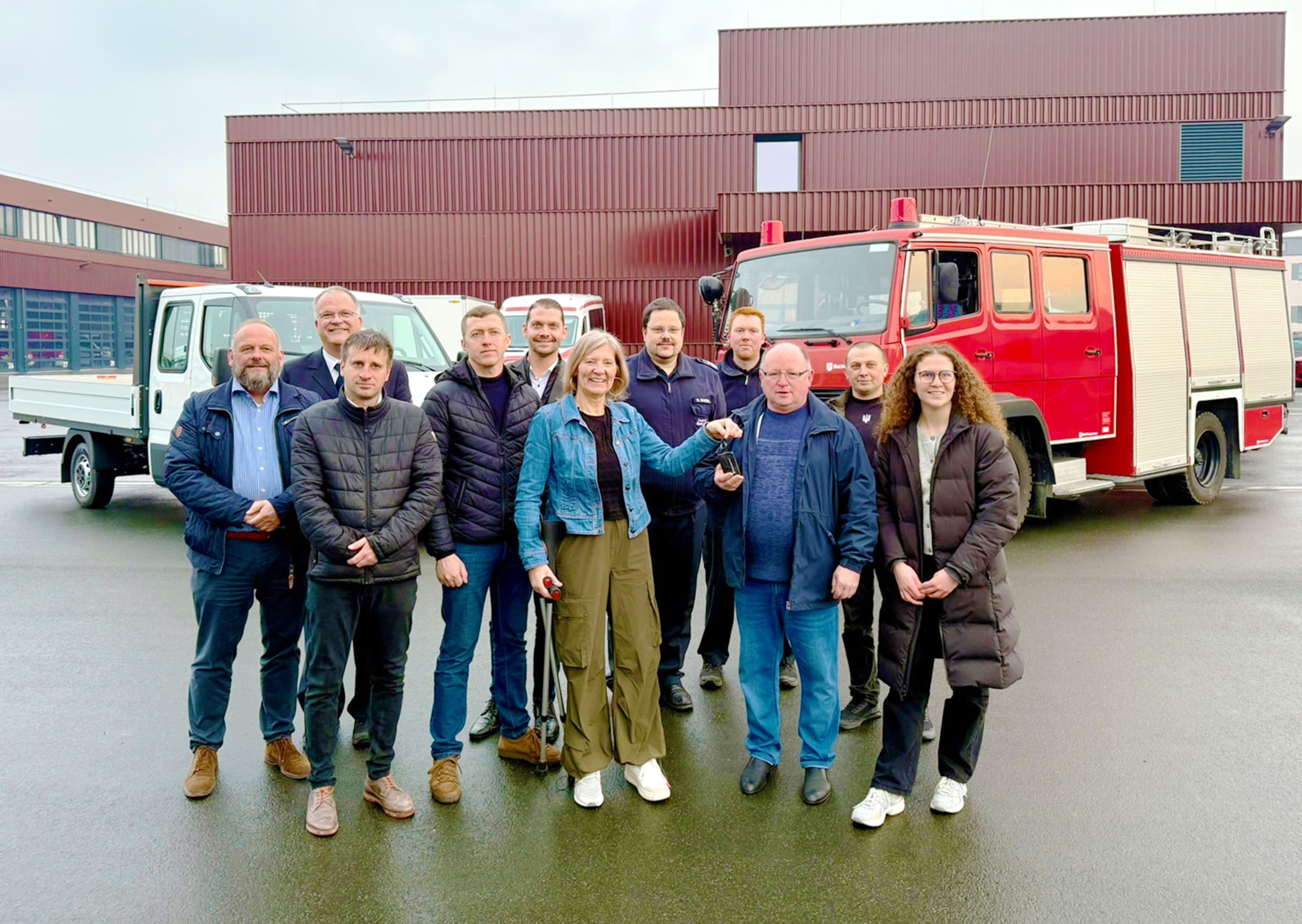 Landrätin Anita Schneider überreicht die Schlüssel für ein Feuerwehrauto und einen Kleintransporter an den Gemeinderatsvorsitzenden Serhii Harus aus der ukrainischen Partnerkommune Ripkyne.