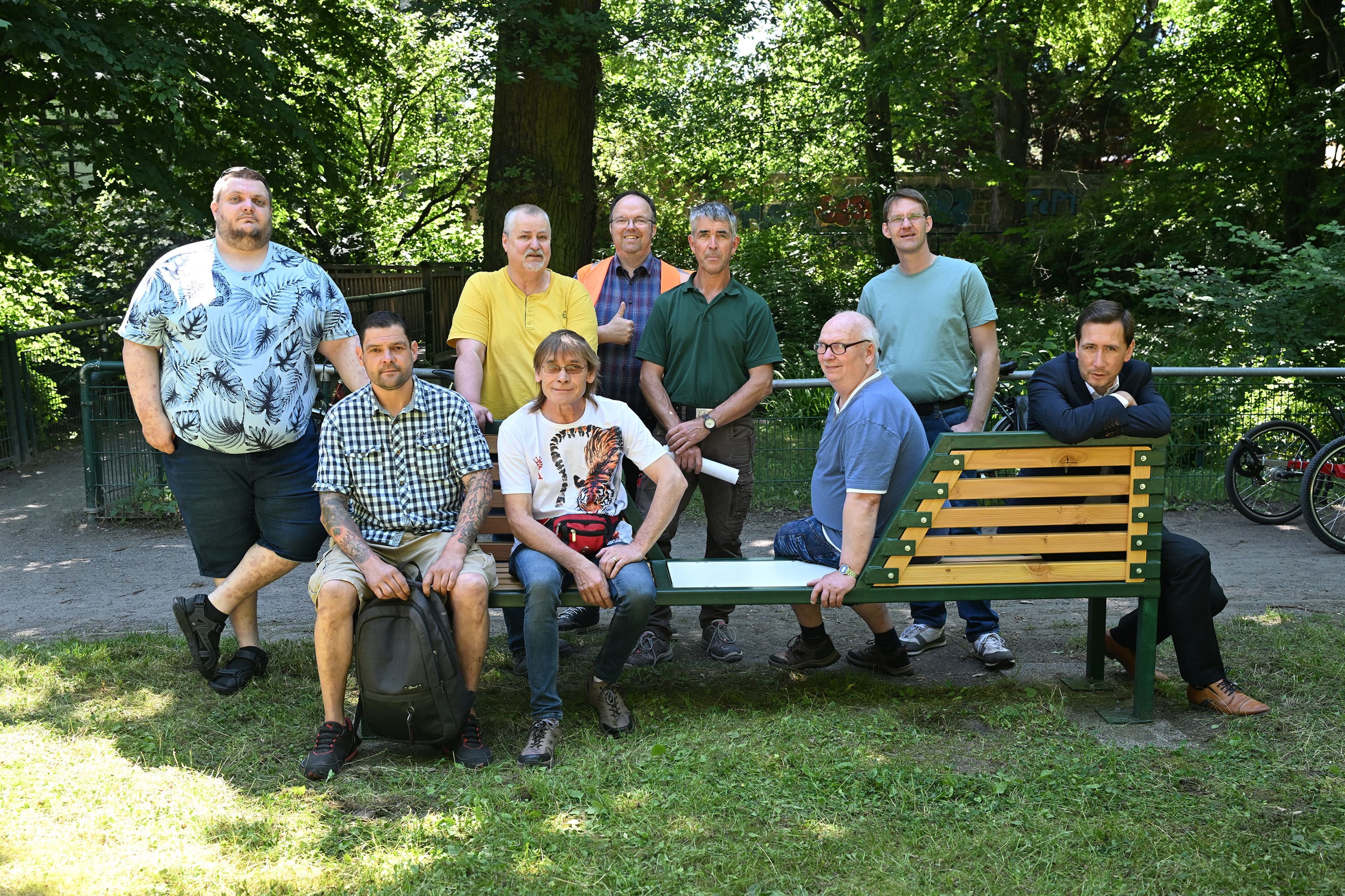 Alle Beteiligten des Projekts sitzen auf den neuen Picknickbänken am Ententeich im Stadtpark Halberstadt.