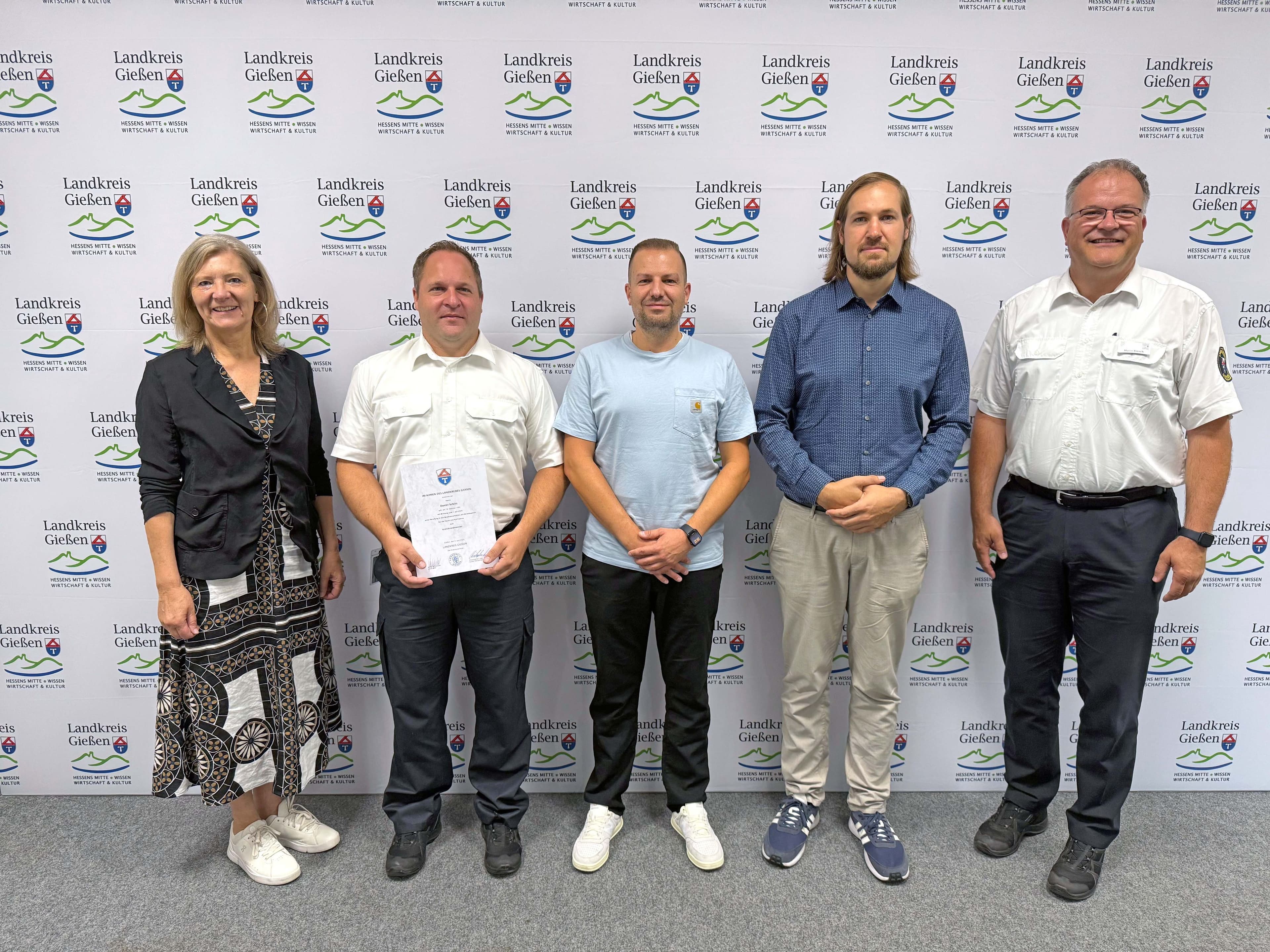 Landrätin Schneider und Kreisbrandinspektor Binsch danken den Ehrenamtlichen Daniel Schlitt, Marcel Krug und Simon Gilbert.