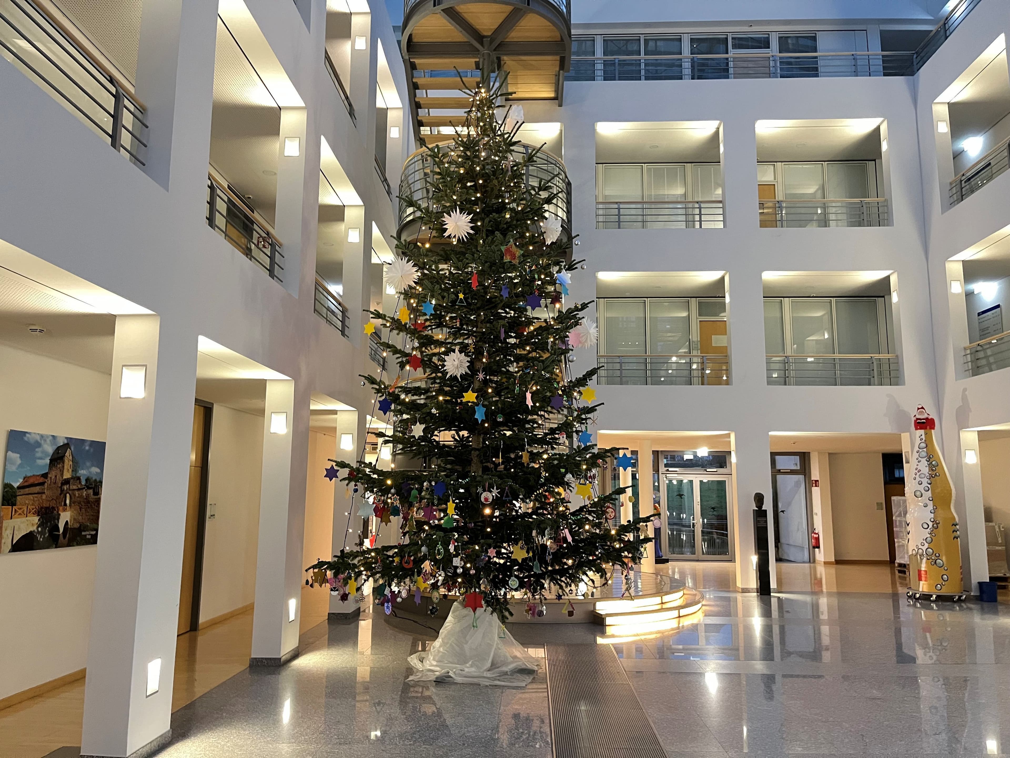 Mit selbstgebasteltem Schmuck aus städtischen Kitas geschmückter Weihnachtsbaum im Rathausfoyer.