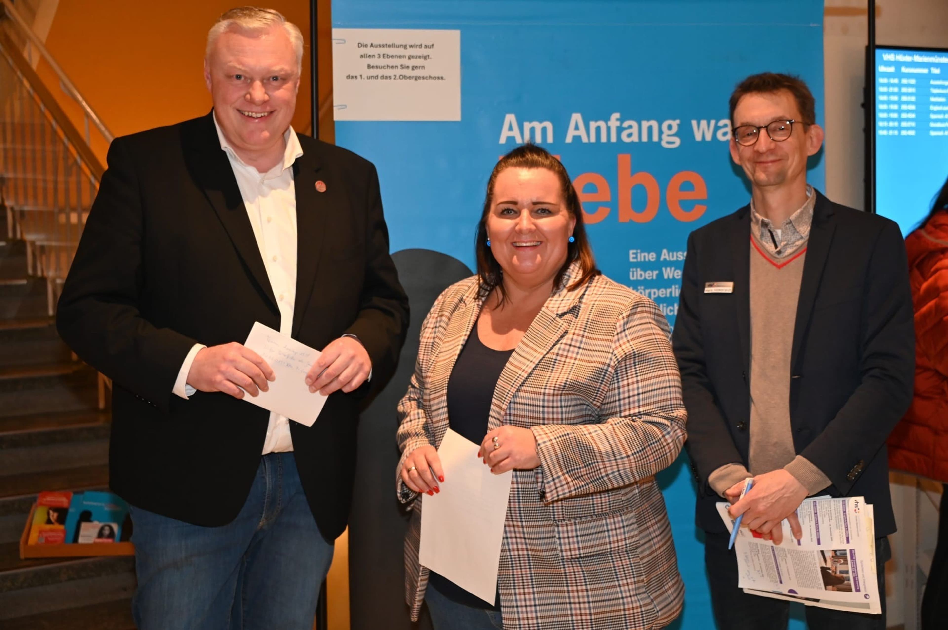 VHS-Leiter Hildebrandt und Nadine Nolte Hartmann eröffnen die Ausstellung "Am Anfang war es Liebe." in der Volkshochschule Höxter.