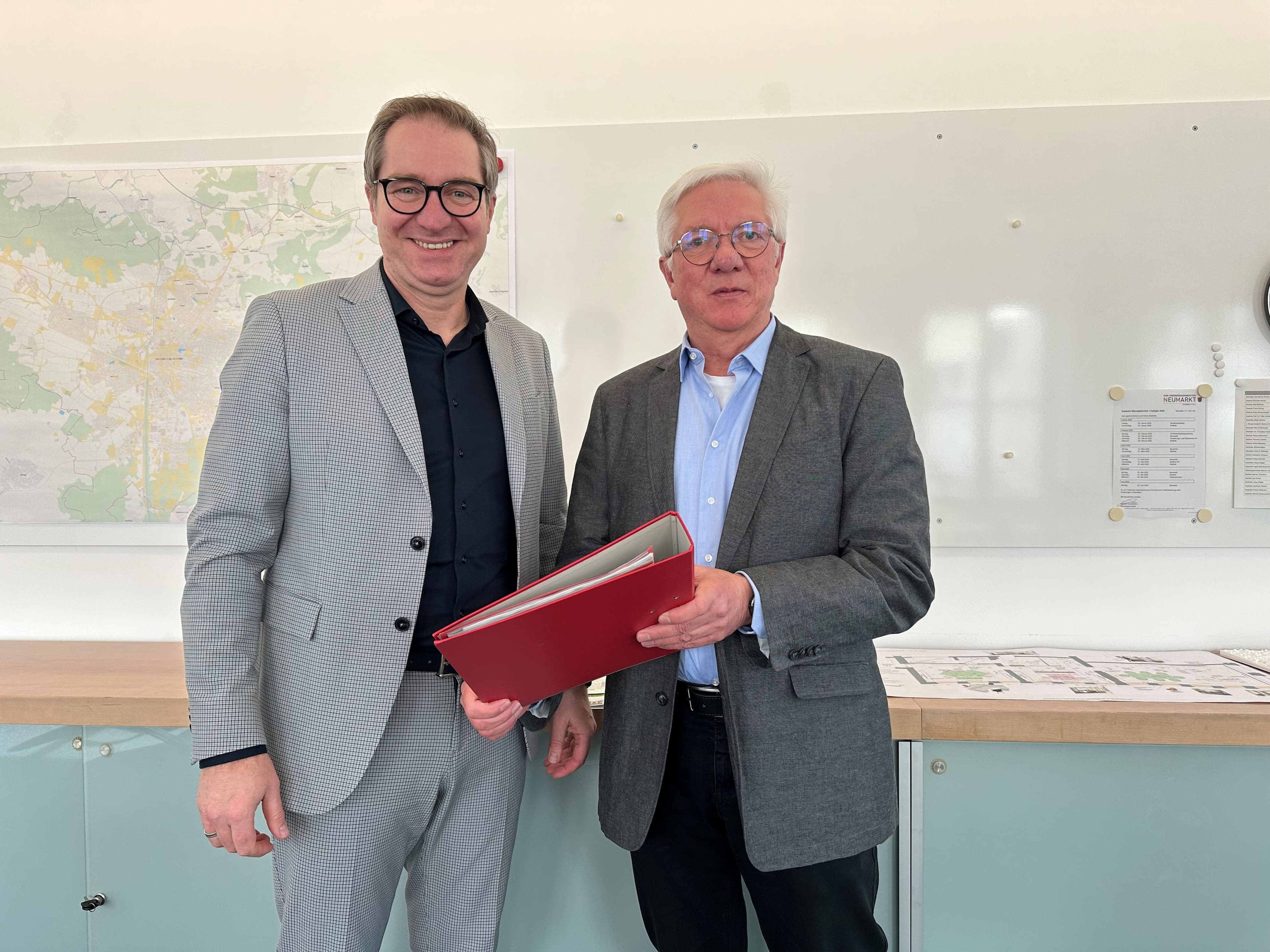 Amtsleiter Alfred Frauenknecht präsentiert die neuesten Ergebnisse des statistischen Jahresberichts zur Bevölkerungsentwicklung in Neumarkt, während Oberbürgermeister Markus Ochsenkühn aufmerksam zuhört.