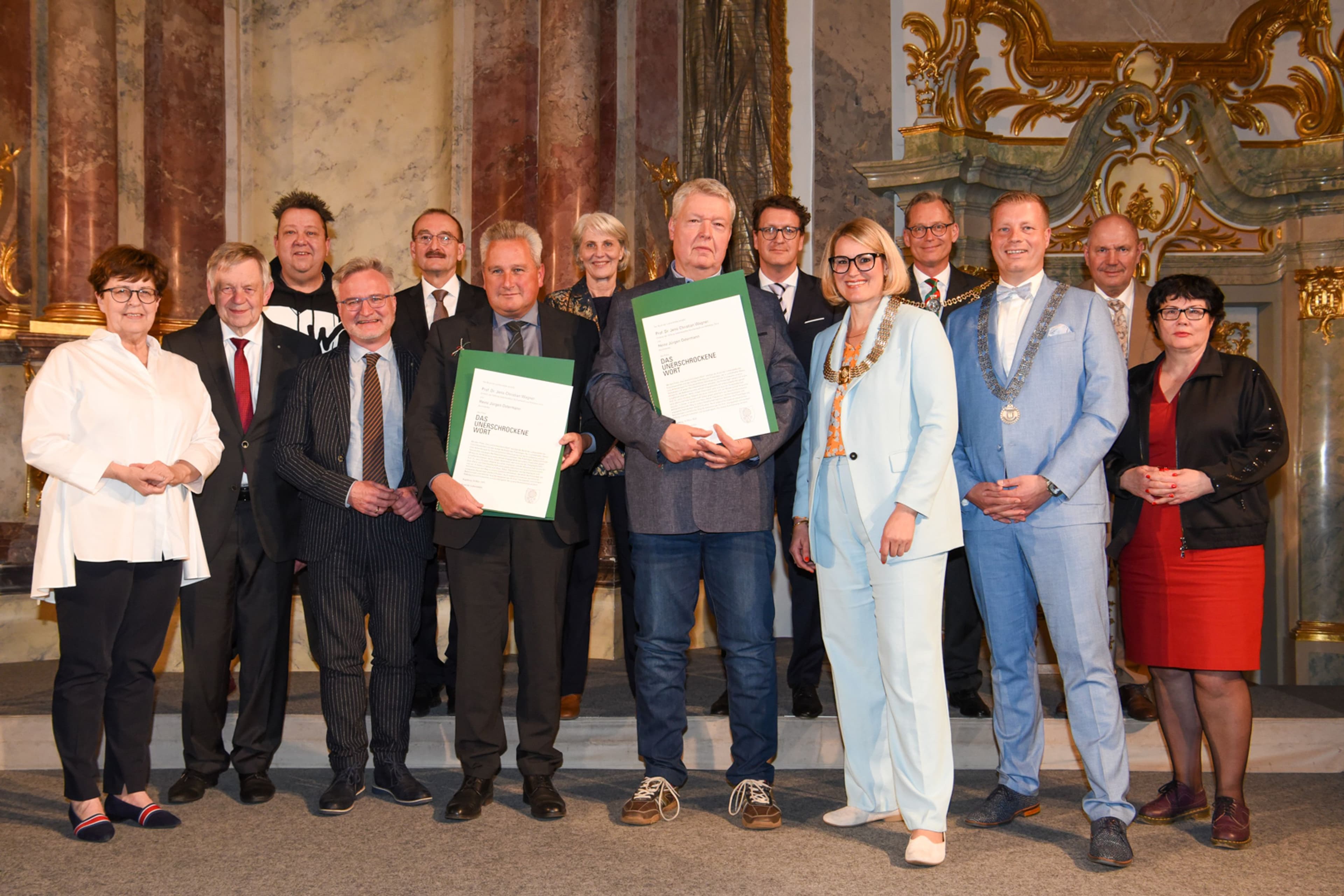Augsburgs Oberbürgermeisterin Eva Weber überreicht Heinz J. Ostermann und Prof. Jens-Christian Wagner die Urkunden zum Preis.