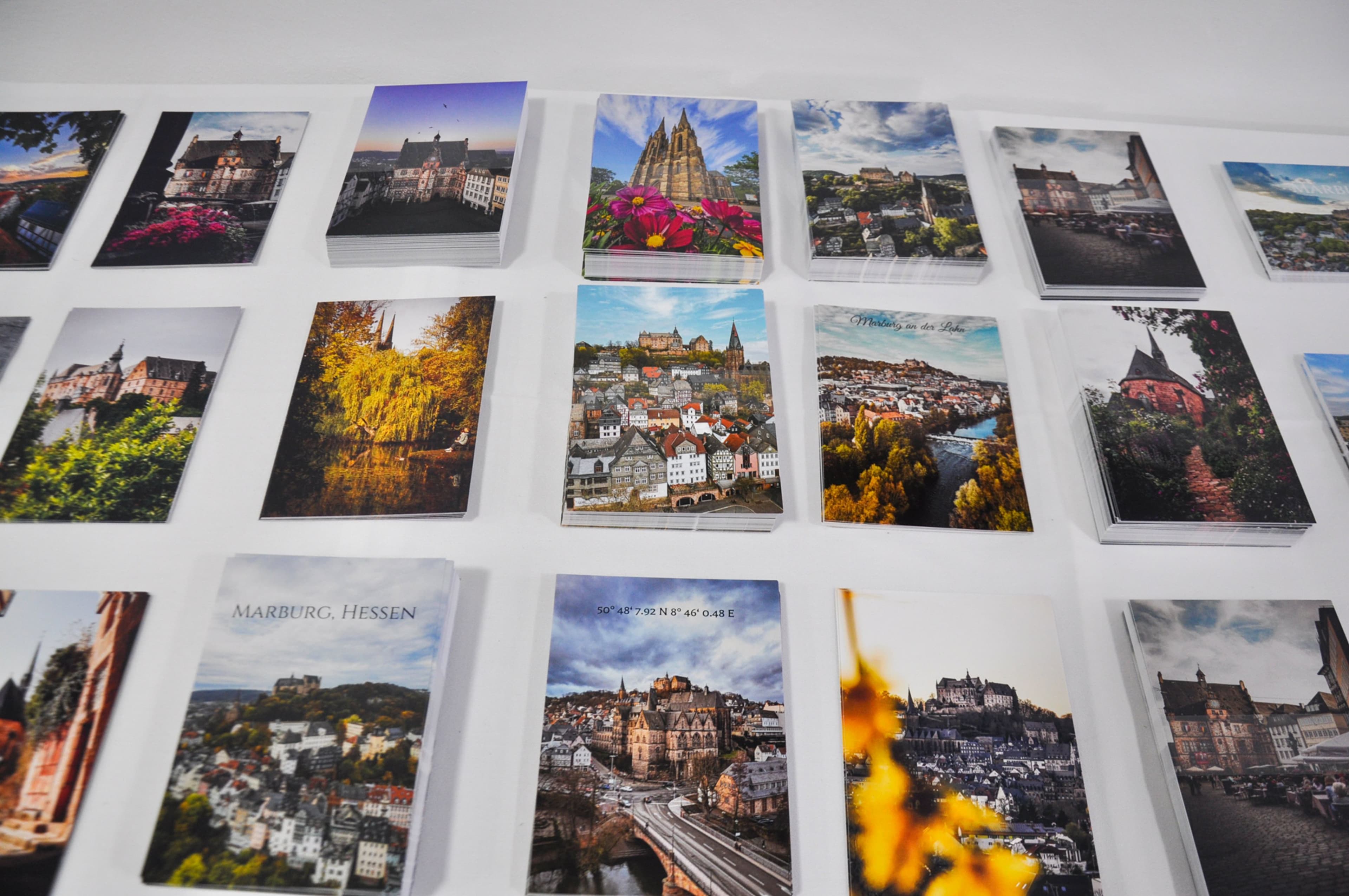 Oberbürgermeister Spies stellt mit Erwin Schul und Team die Fotoausstellung im VielRAUM vor., Plakate und Postkarten mit Motiven aus Marburg und der ganzen Welt von Erwin Schul im VielRAUM.