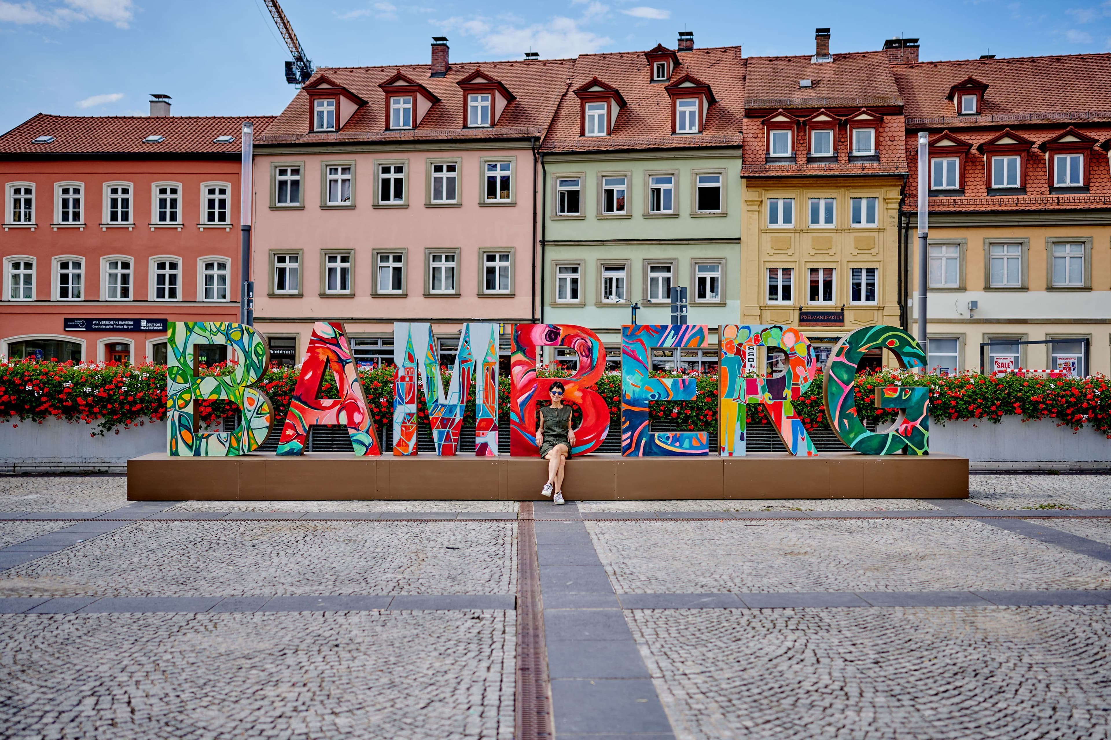 Die verstorbene Künstlerin Barbara Bollerhoff präsentiert den Bamberg-Schriftzug am Maxplatz.
