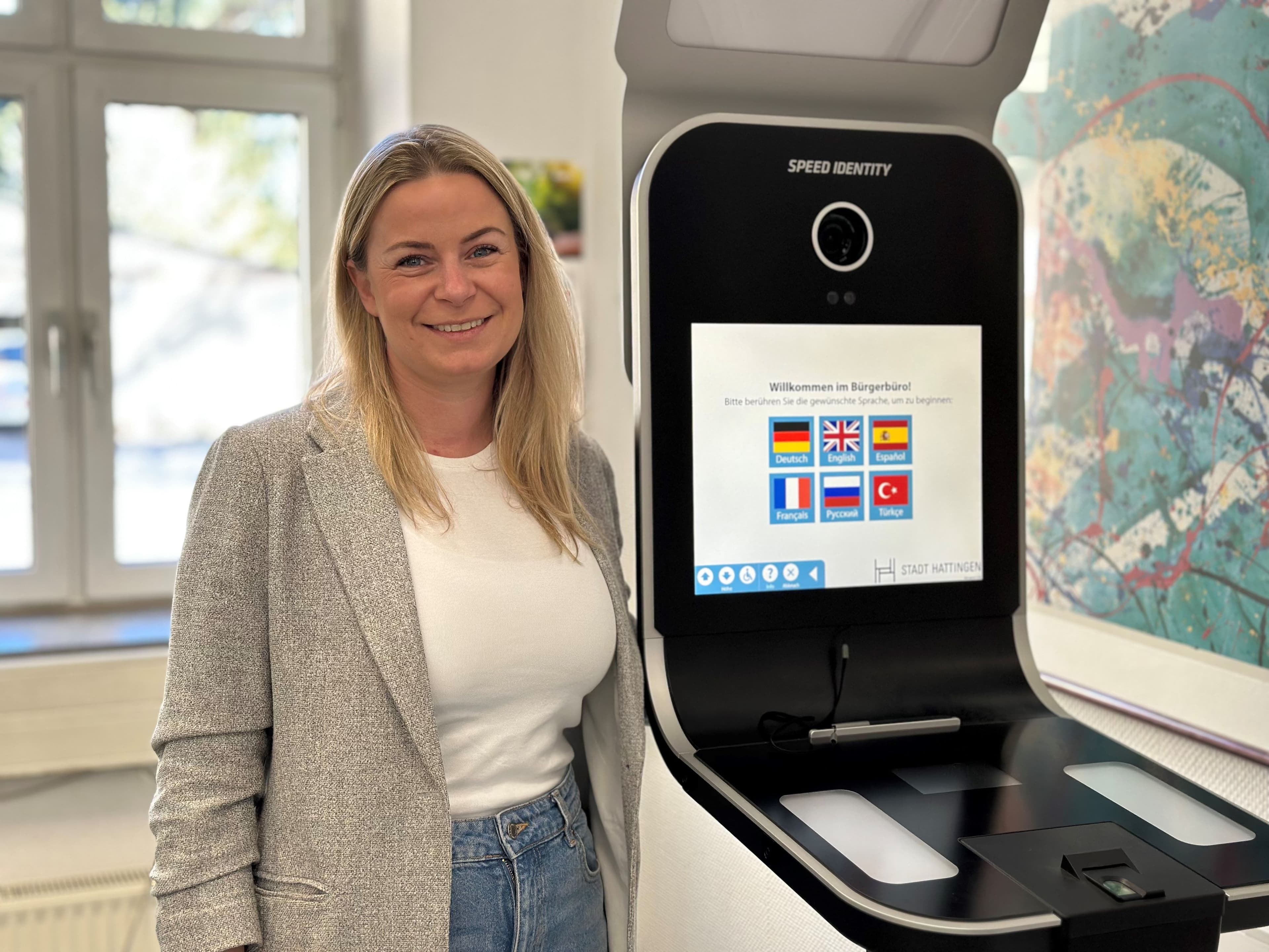 Die Leiterin des Bürgerbüros steht neben dem neuen Fototerminal im Bürgerbüro Hattingen.
