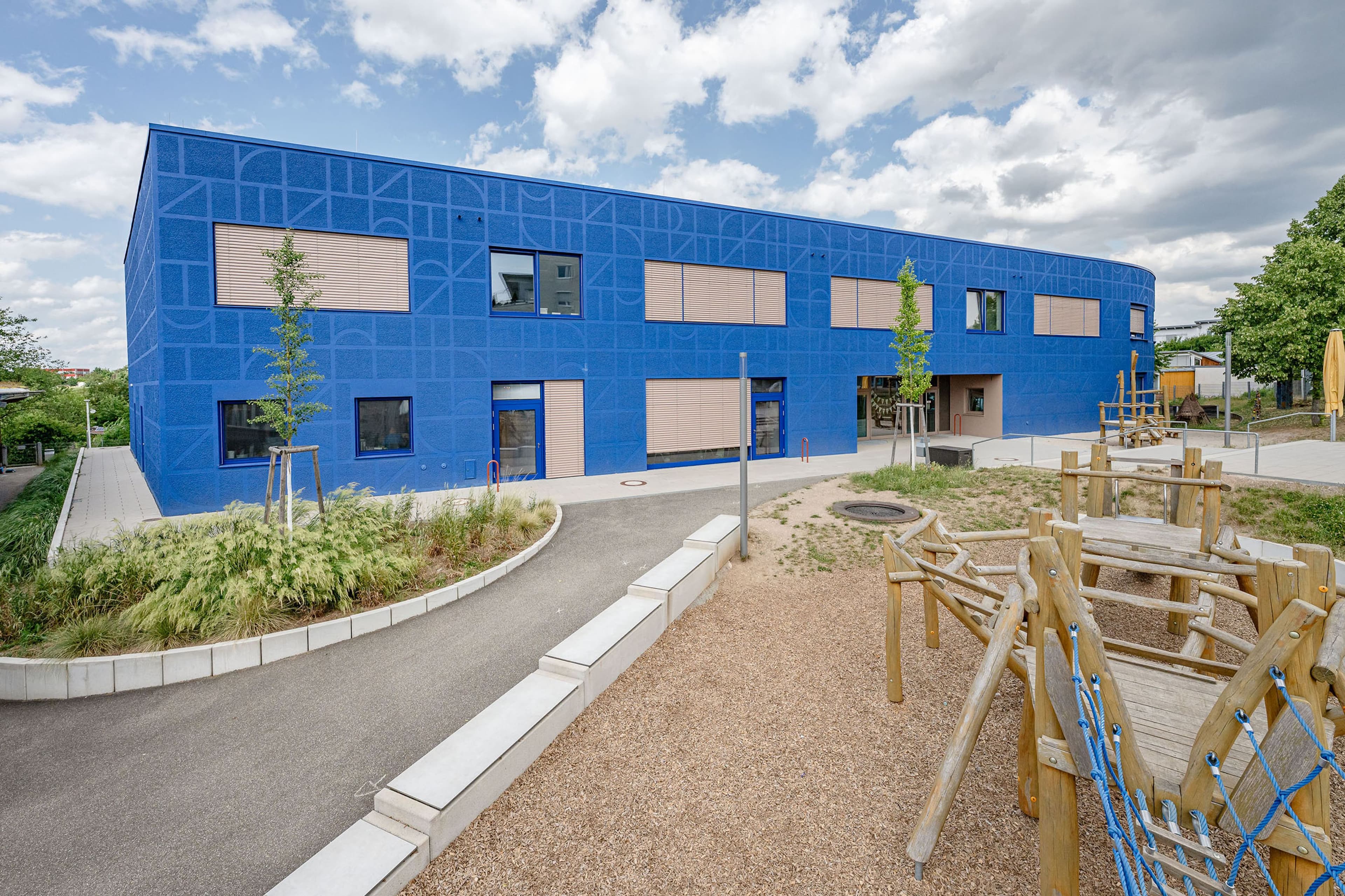 Sanierte Maria Montessori Grundschule Stuttgart-Weilimdorf mit markanter blauer Fassade und modernen Lernräumen.