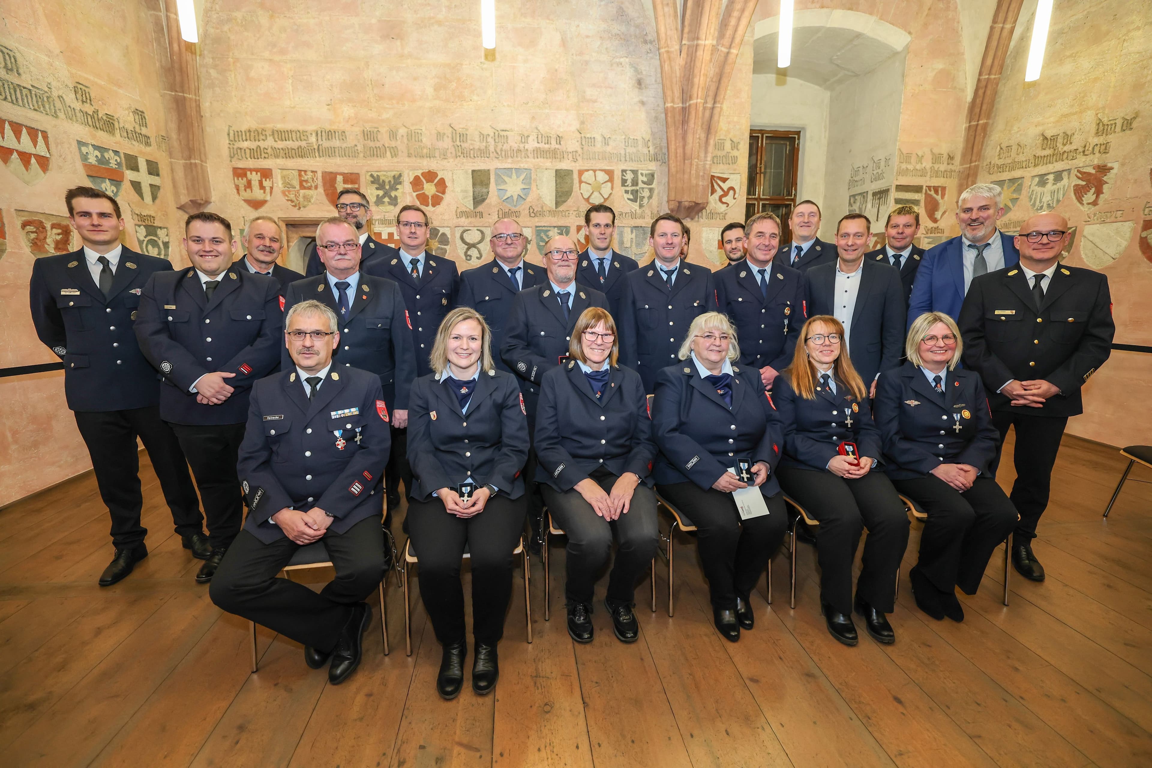 Gruppe geehrter Feuerwehrleute mit Bürgermeister, Landrat und Feuerwehrführung beim Ehrenabend.