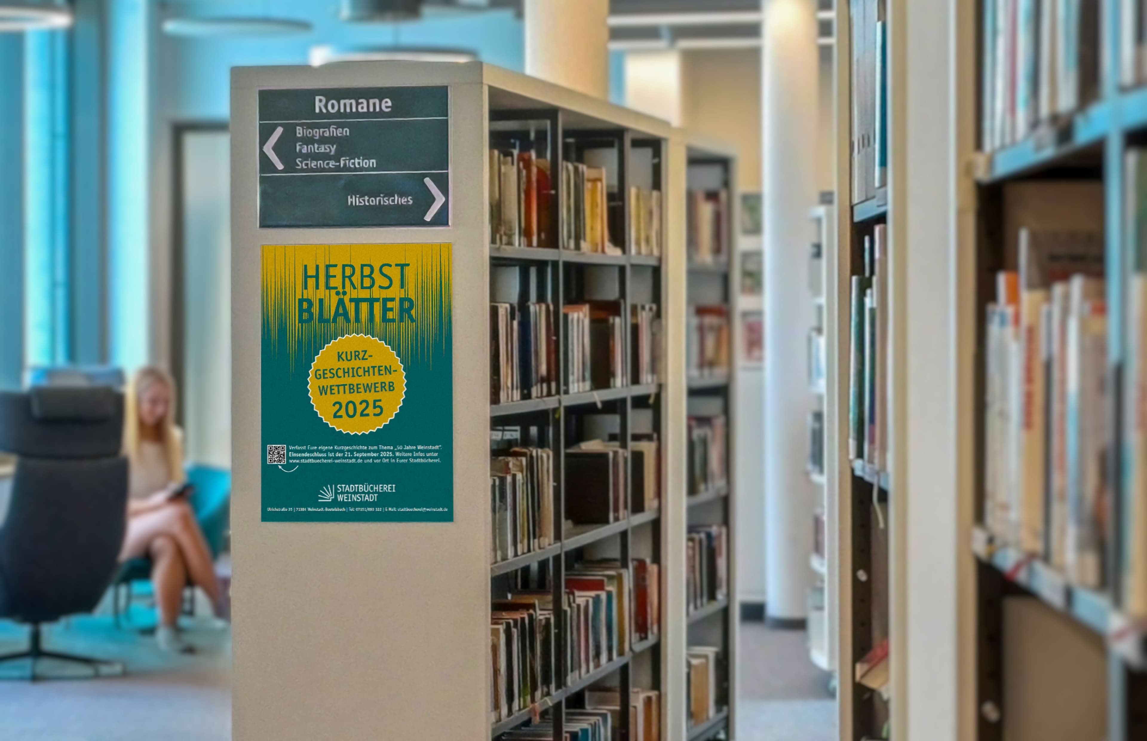 Blick in die Stadtbücherei mit Ankündigung des Kurzgeschichtenwettbewerbs 2025.