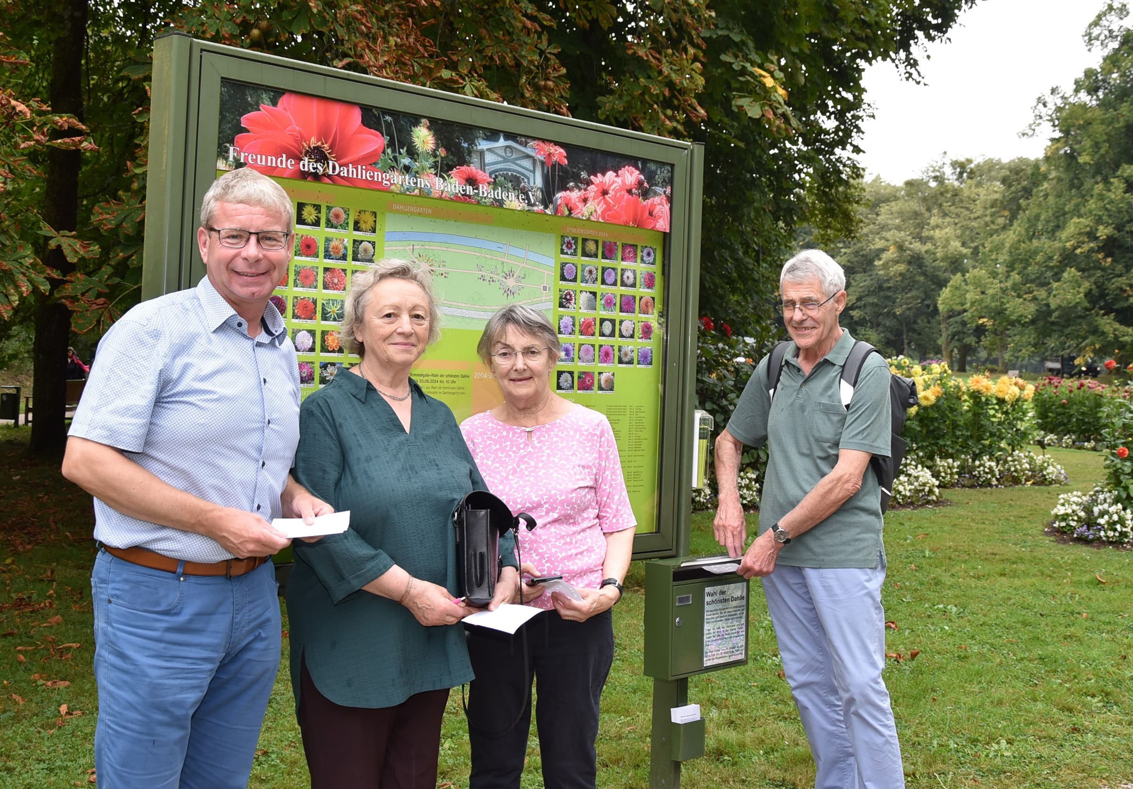 Ferdinand und Doris Föry, Cäcilia Amalie Kaiser-Kaas sowie Markus Brunsing am Stimmzettelkasten im Dahliengarten während der Wahl der schönsten Dahlie 2024 in Baden-Baden.