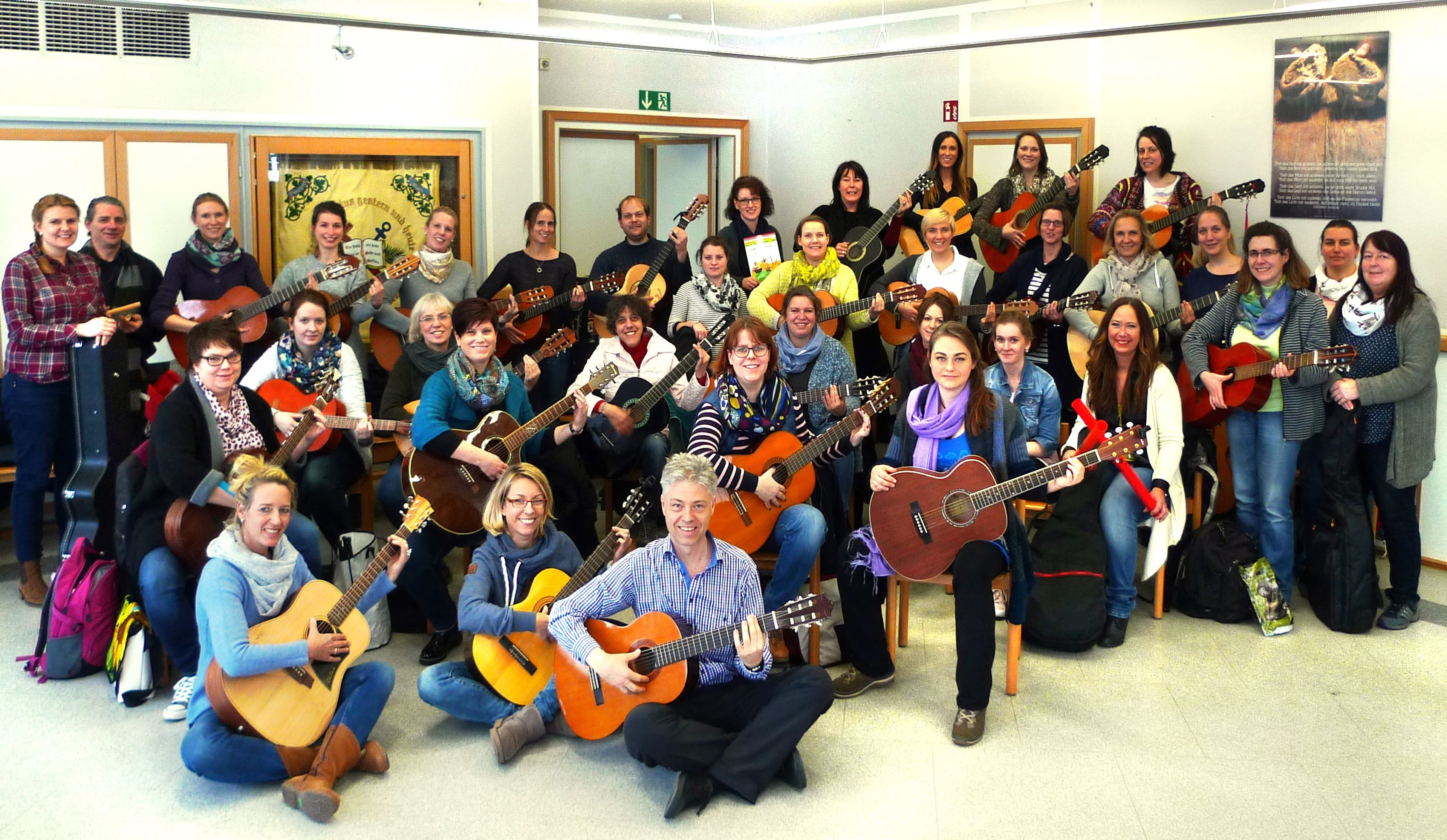 Teilnehmer eines JelGi-Gitarrenkurses in der Stadtbibliothek Minden musizieren gemeinsam.