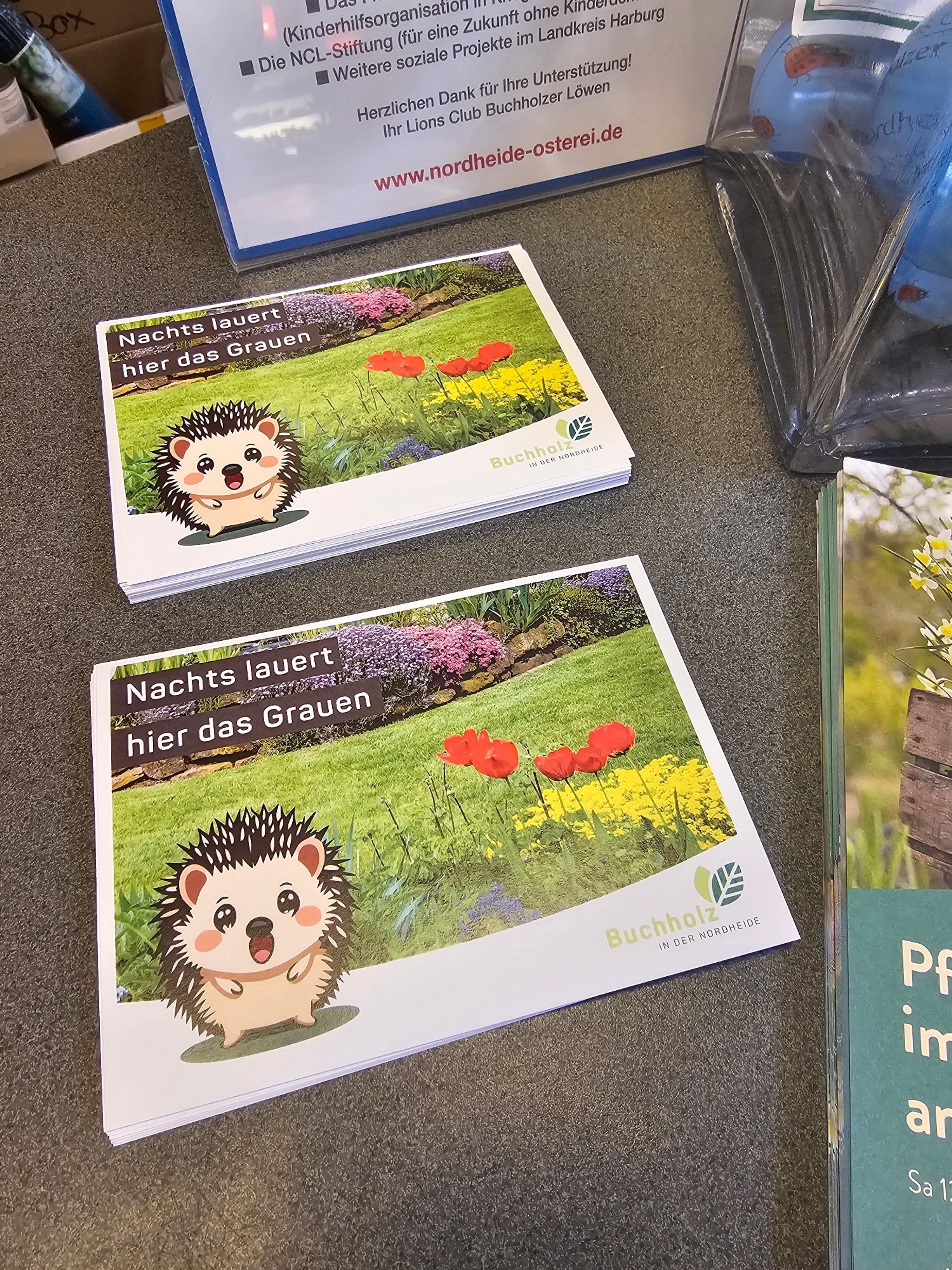 Stadt Buchholz startet Tierschutz-Kampagne und verteilt Postkarten zum Schutz von Igeln vor Mährobotern.