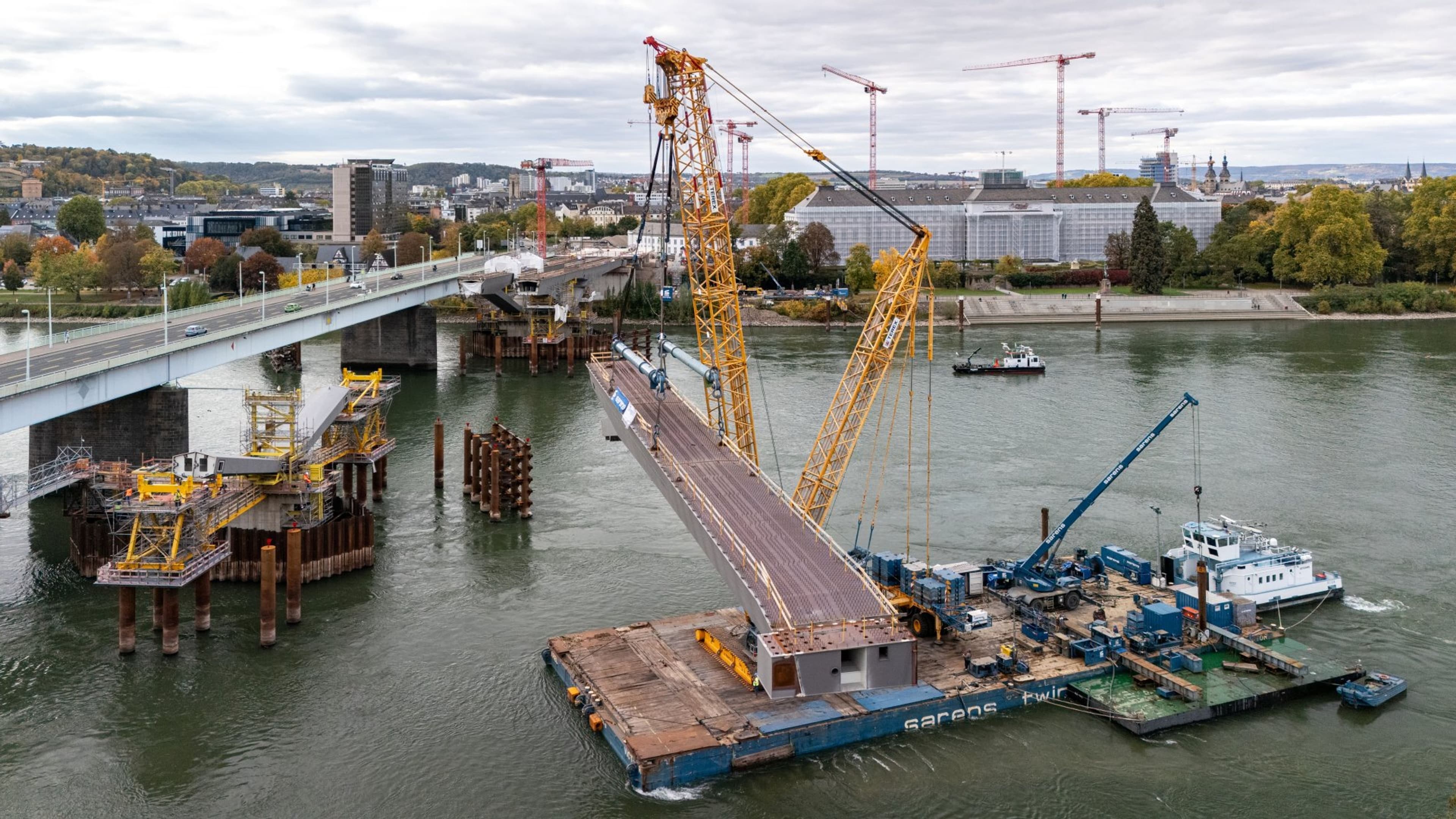 Luftaufnahme: Erste Stahlbauteile auf der Pfaffendorfer Seite per Kran eingehoben.