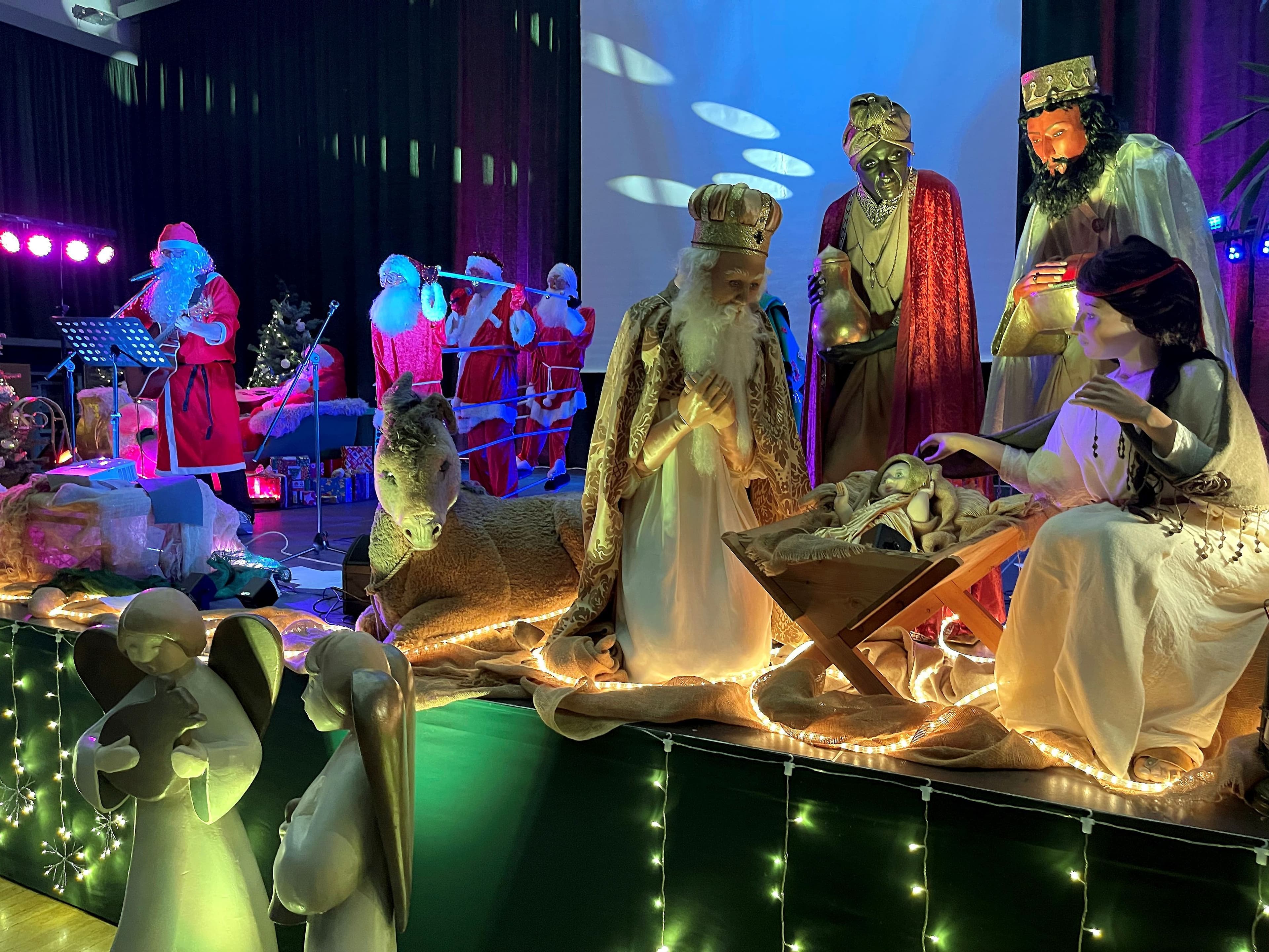 Aufwendige Bühnendeko mit lebensgroßen Krippenfiguren bei der Seniorenweihnachtsfeier.
