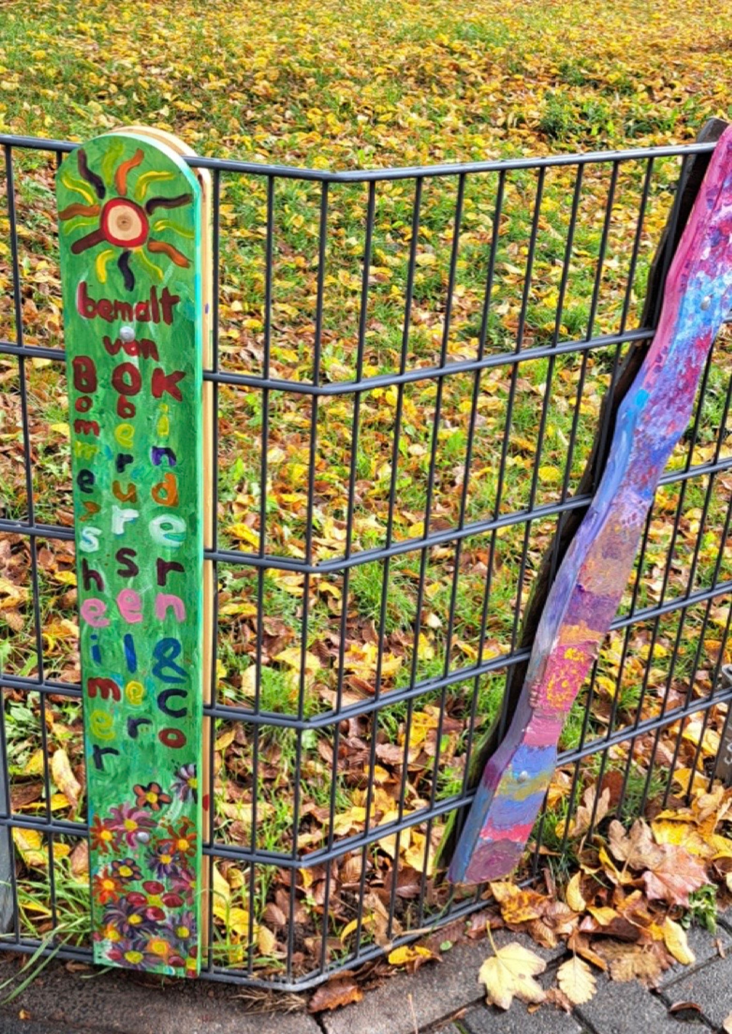 Pierre Dieudegard vom BSO bringt bunte Zaunlatten in der Maximilian-Kolbe-Straße an., Bunte Zaunlatten schmücken den neuen Treffpunkt in der Maximilian-Kolbe-Straße.