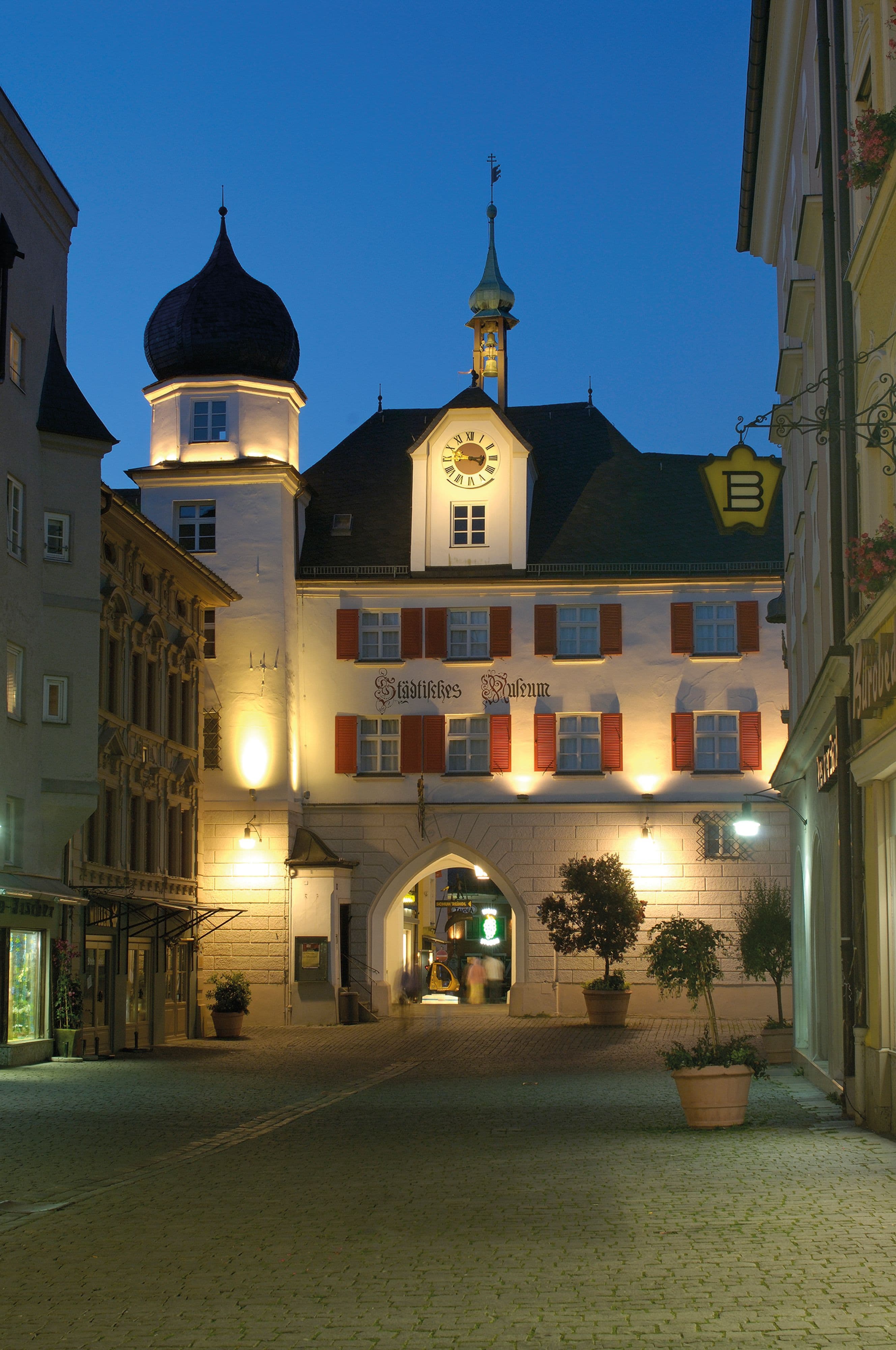 Das Mittertor bei Nacht, stimmungsvoll beleuchtet im Zentrum von Rosenheim.