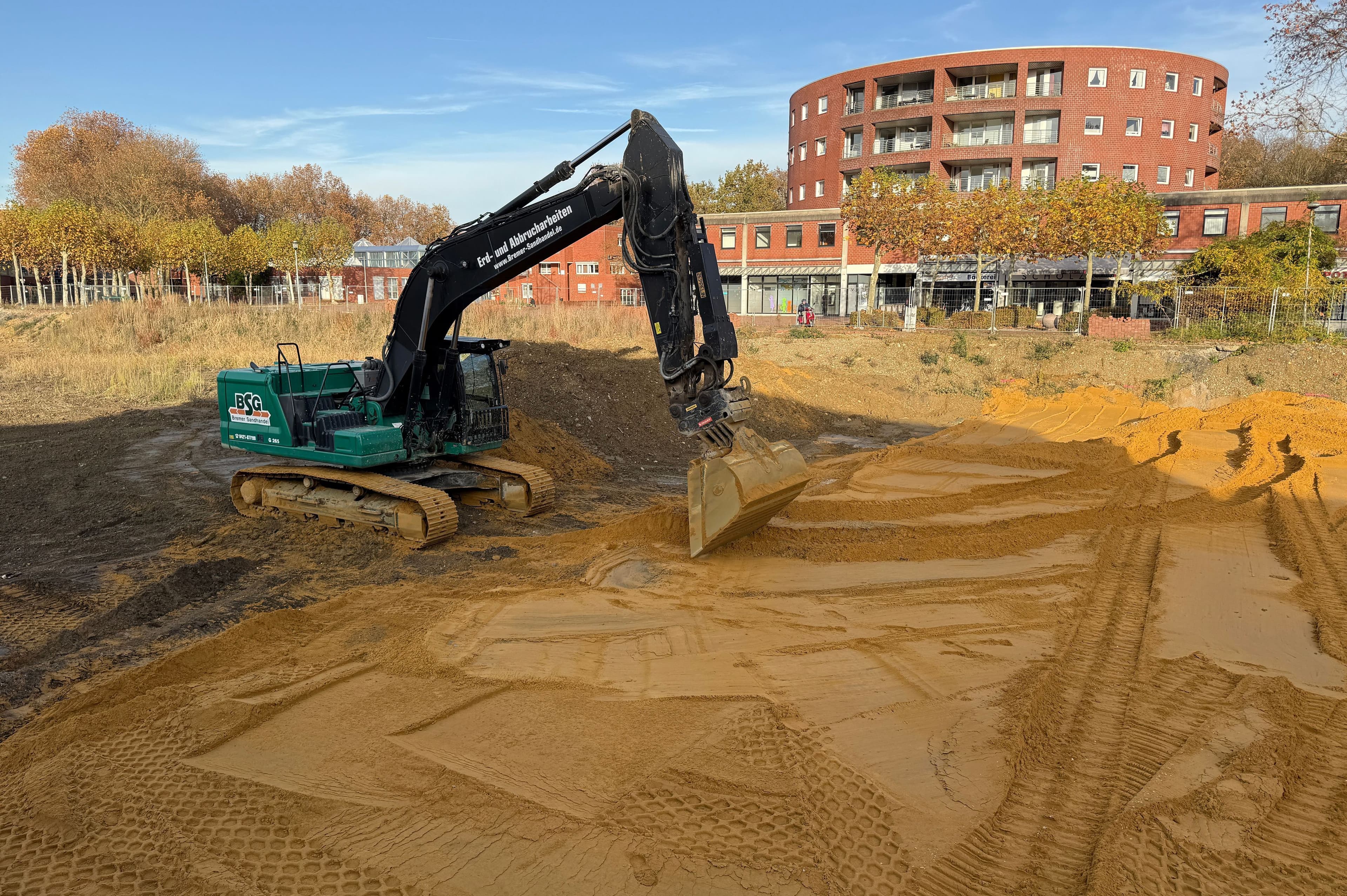 Beauftragte befestigen provisorisch einen Parkplatz auf der Abrissfläche der Ladenzeile Wulfener Markt.