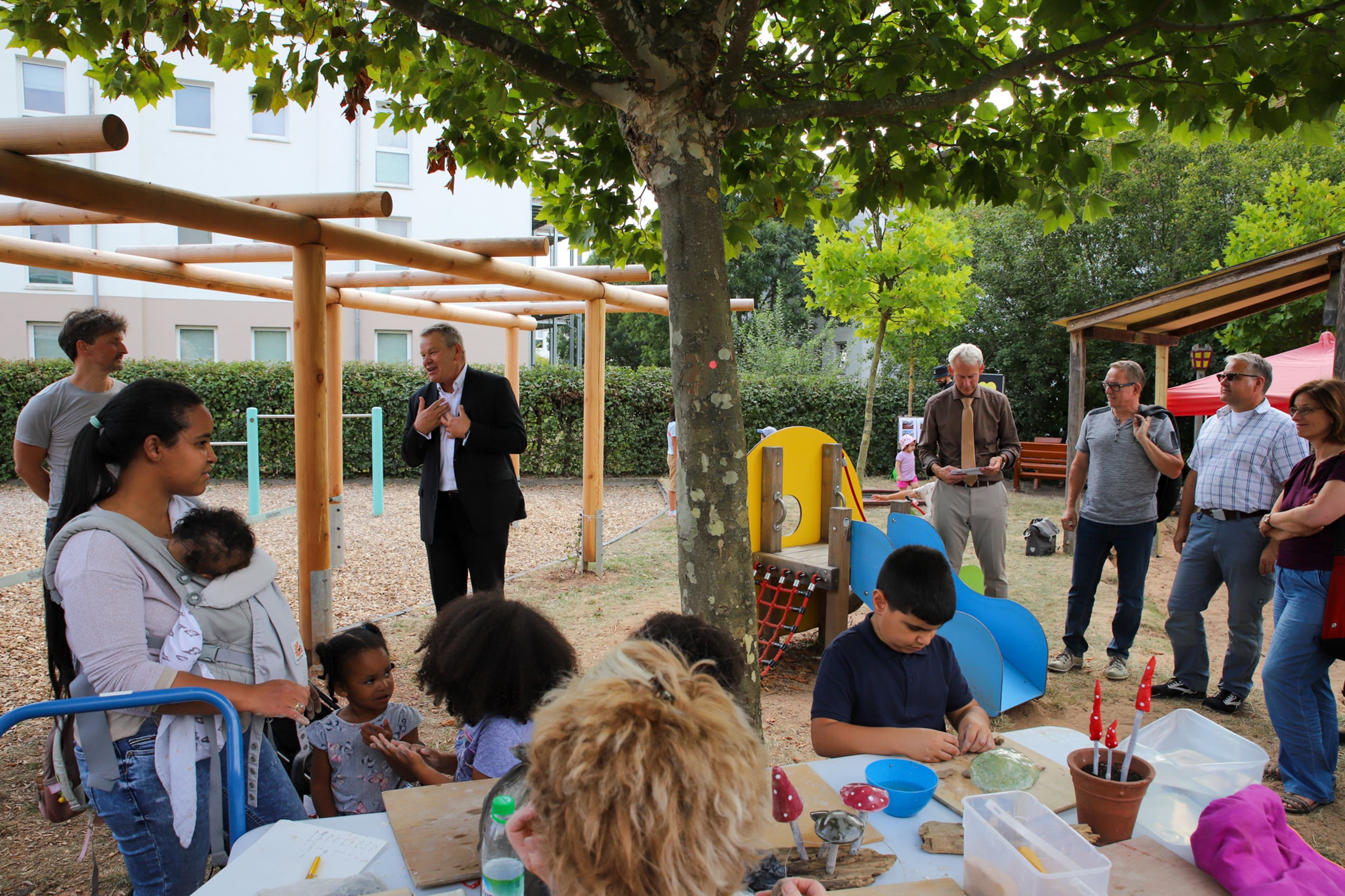 Einweihung der Pergola am Spielplatz 'Paris' mit Kindern, Eltern, Oberbürgermeister und Stadtrat.