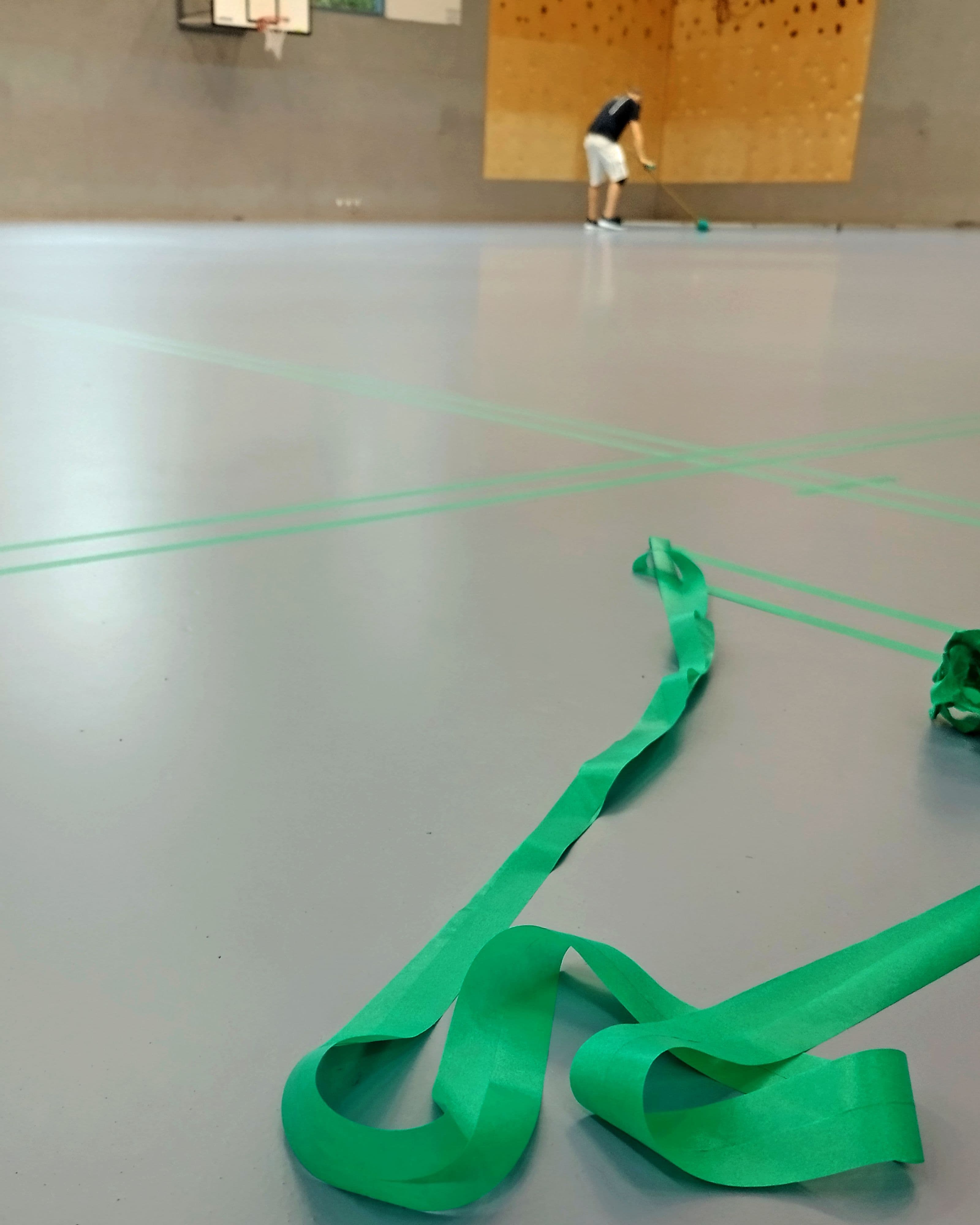 Hallenboden der Sporthalle Weidenweg wird für neue Spielfeldmarkierungen vorbereitet.