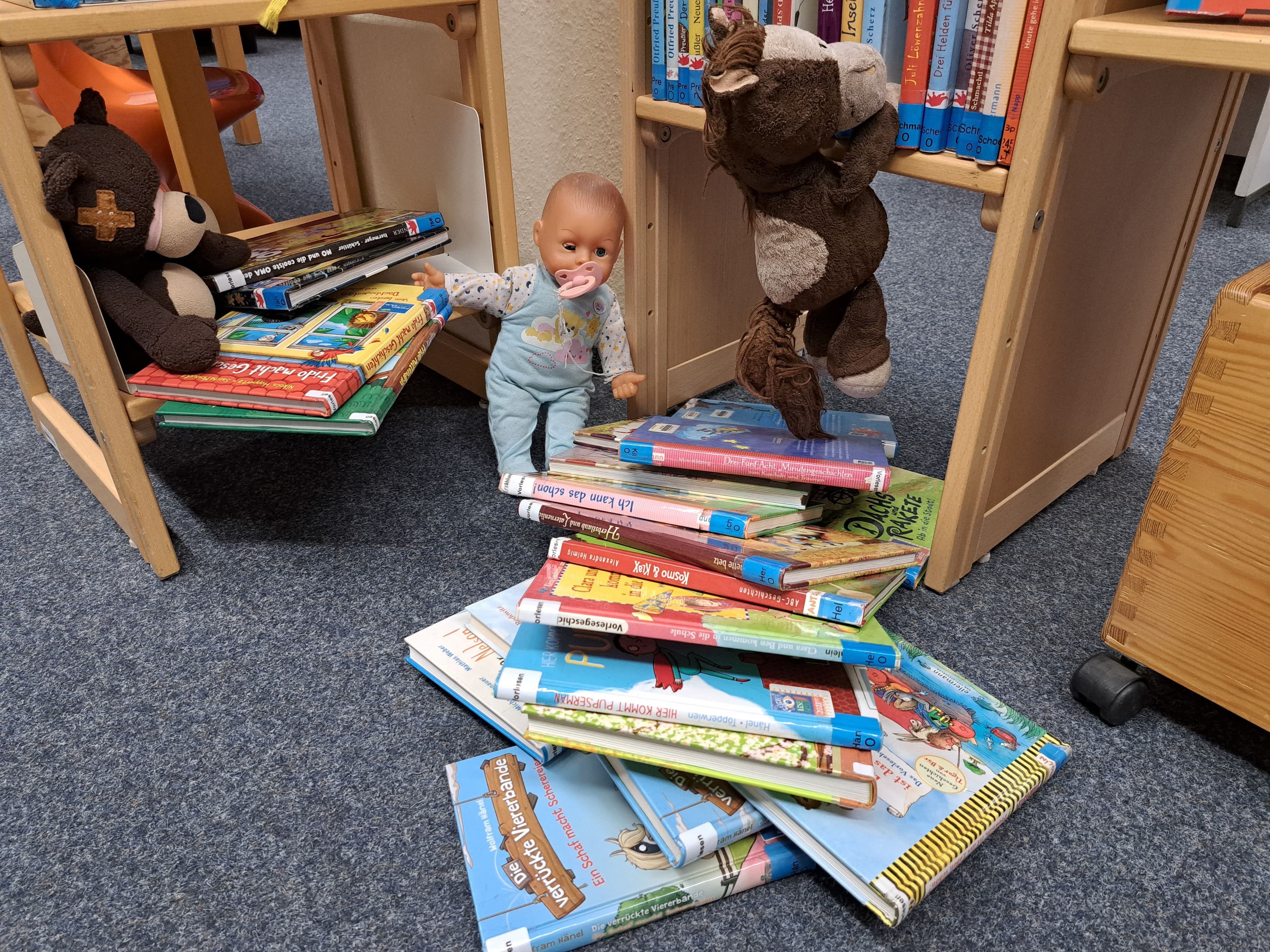 Kinder feiern mit ihren Stofftieren den Tag der Bibliotheken in der Stadtbücherei Schleswig.