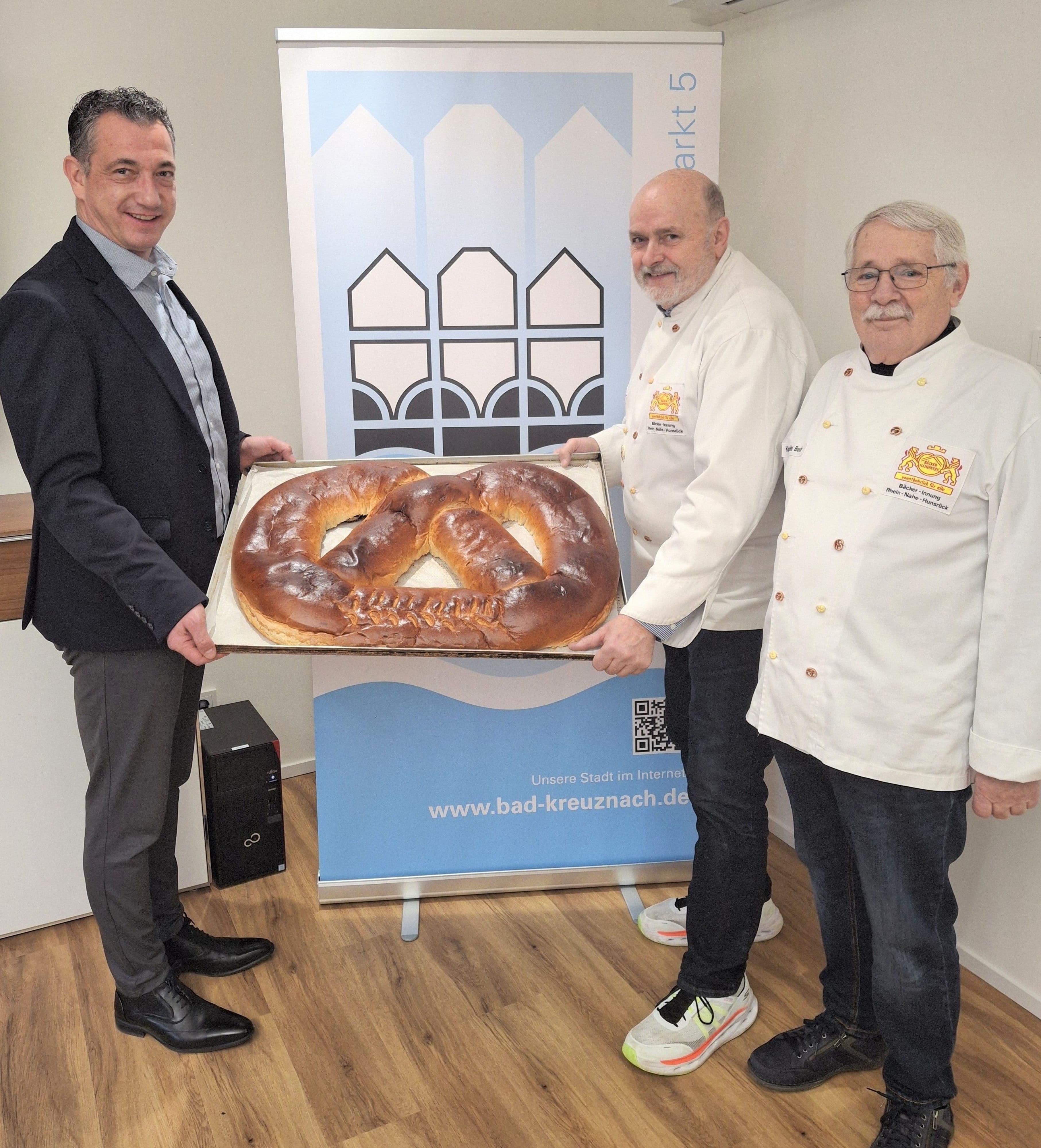Bäckerobermeister Alfred Wenz überreicht die traditionelle Neujahrsbrezel an OB Emanuel Letz im Rathaus Bad Kreuznach.