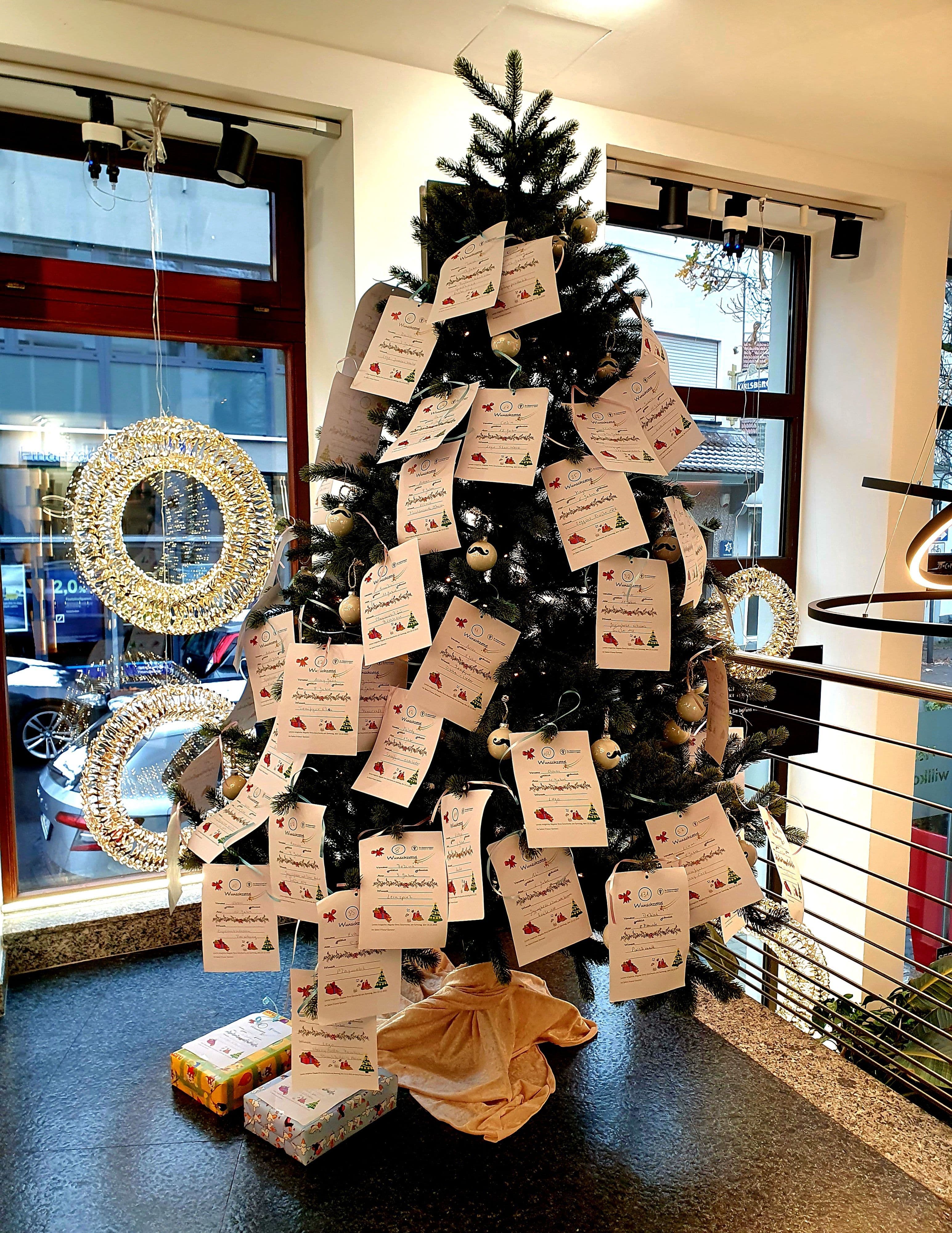 Weihnachtswunschbaum im Friseursalon Ganster lädt zum Wünschepflücken für Kinder ein.